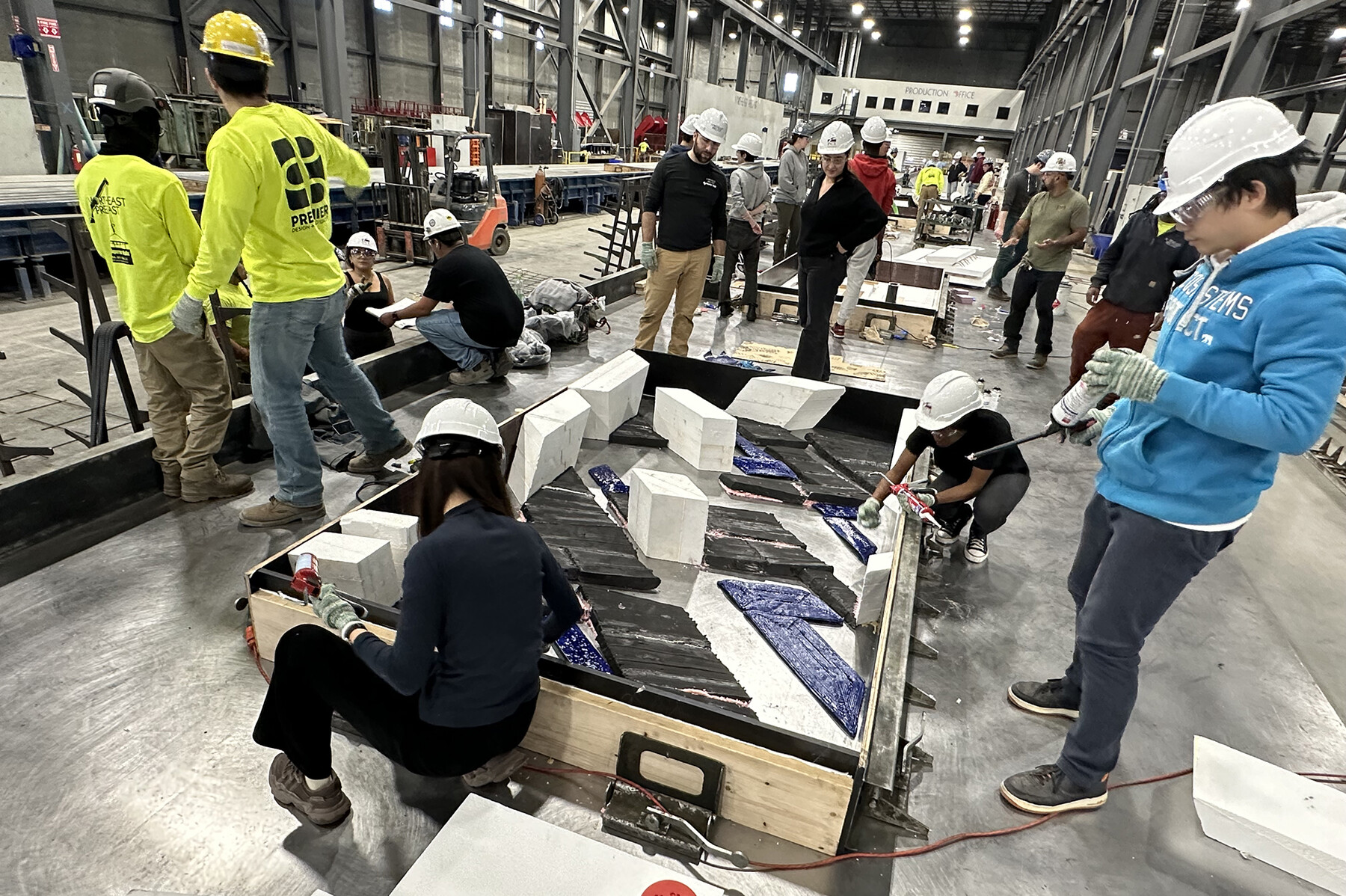 Students building the concrete structures in a large lab space.