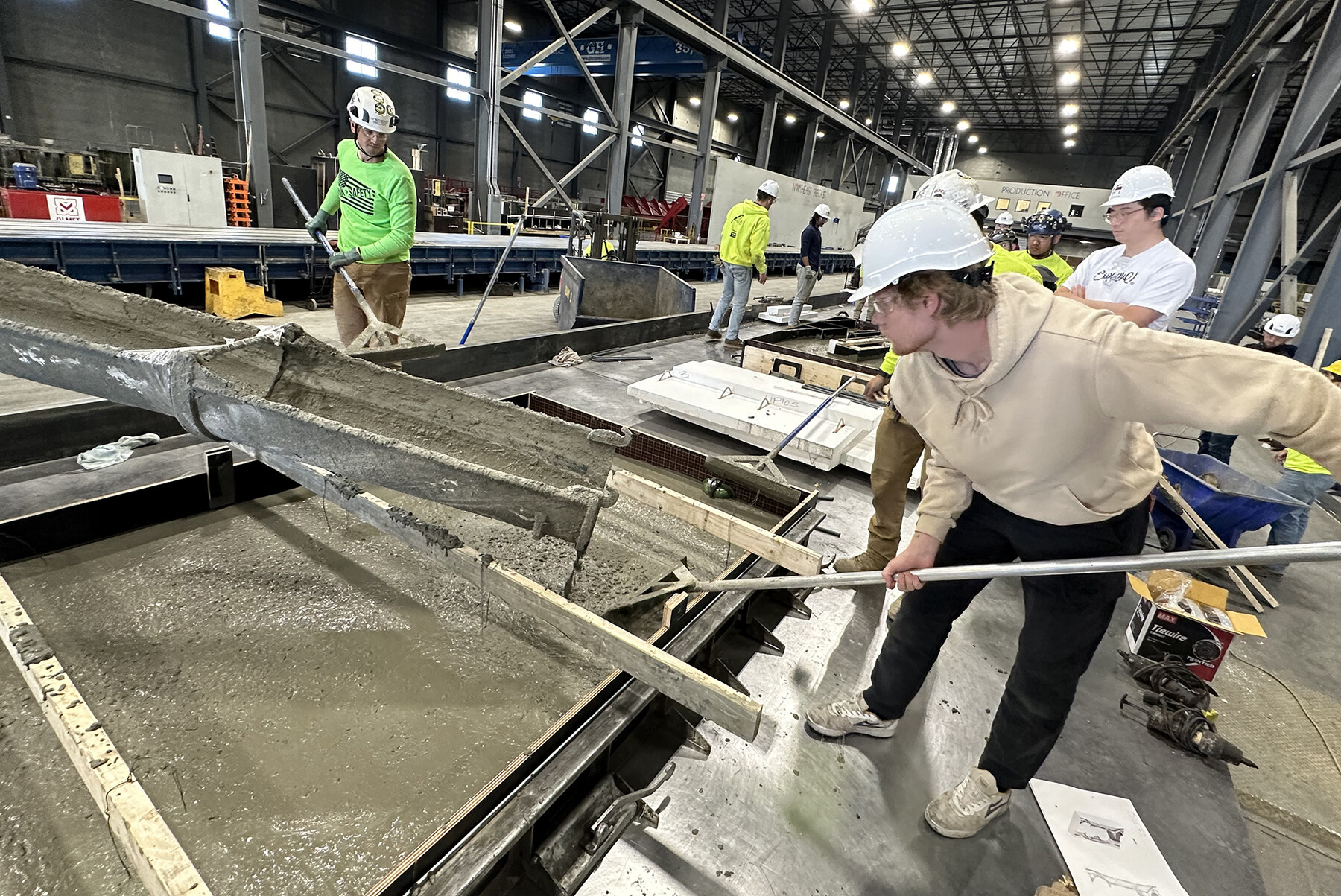 Students constructing the concrete panels in front of the Weitzman School in a large fabrication lab.