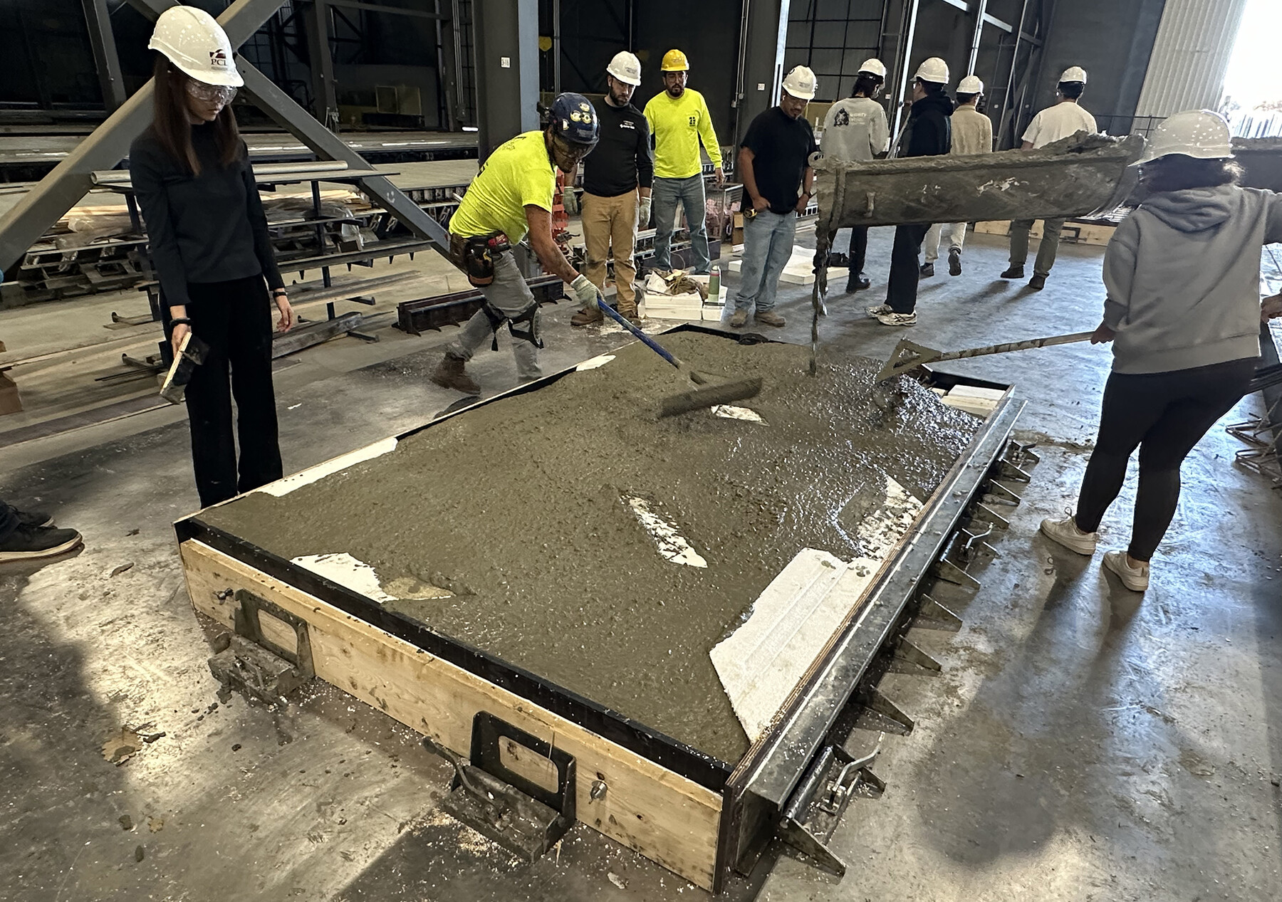 Students constructing the concrete panels in front of the Weitzman School in a large fabrication lab.