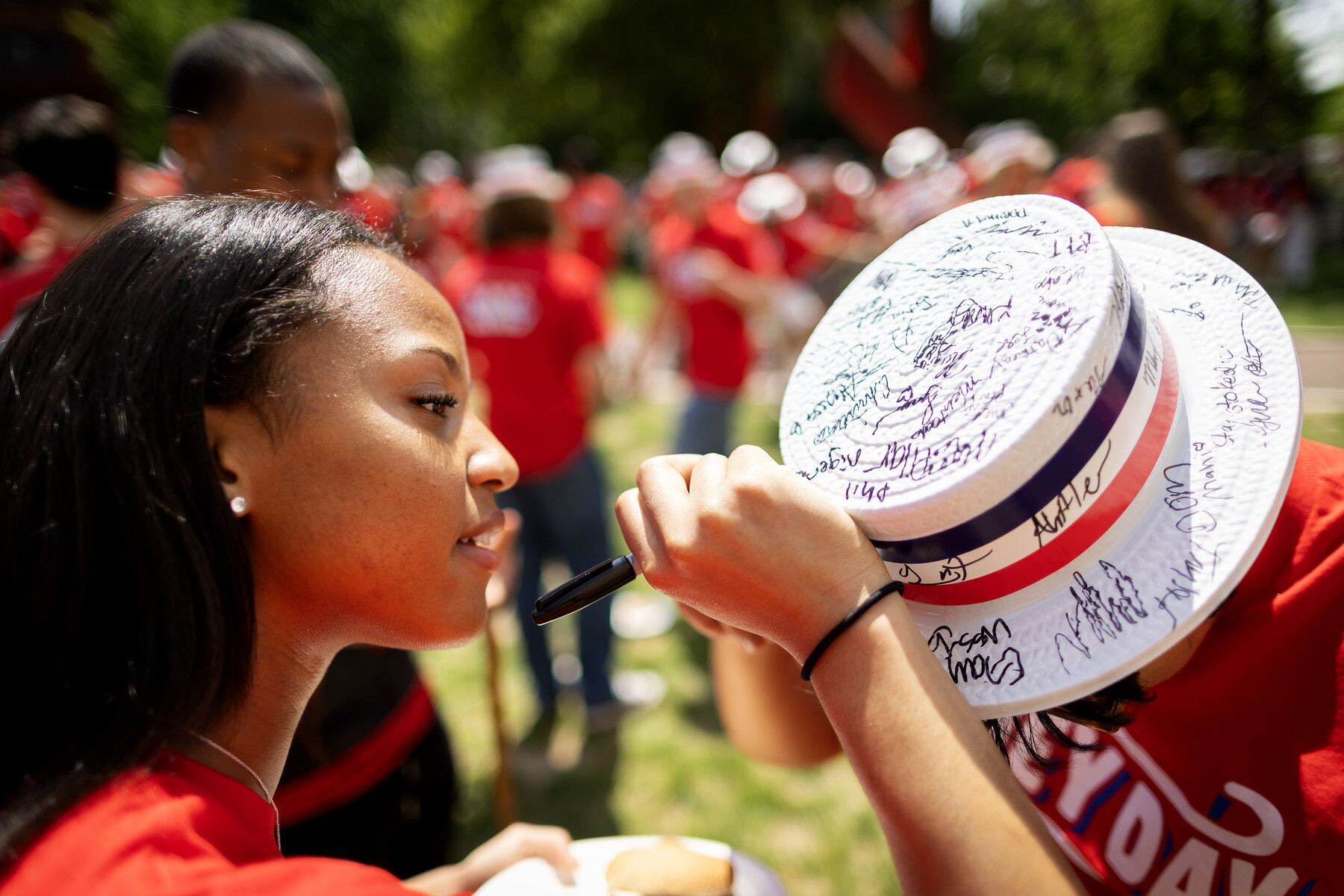 A student signing another student’s hat on Hey Day.