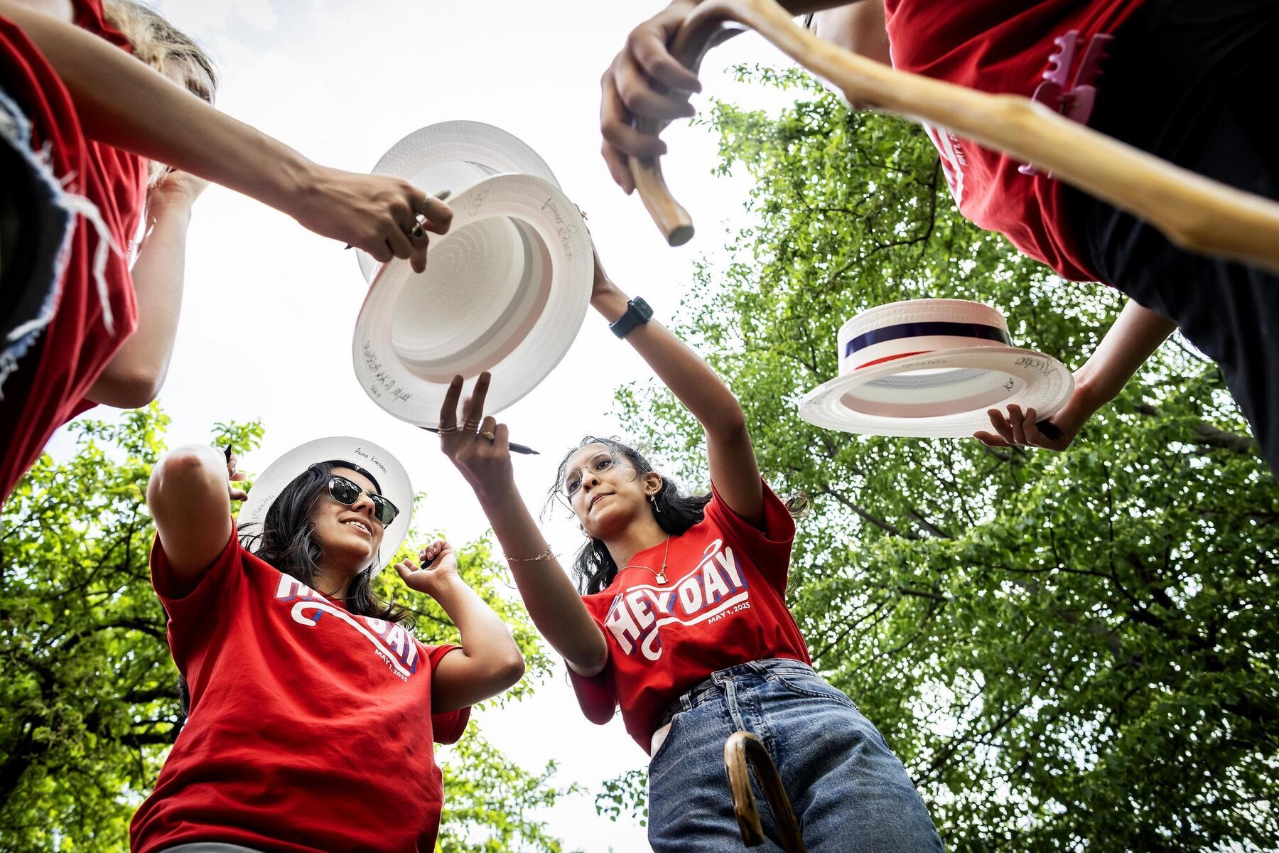Students signing hats during Penn’s Hey Day.