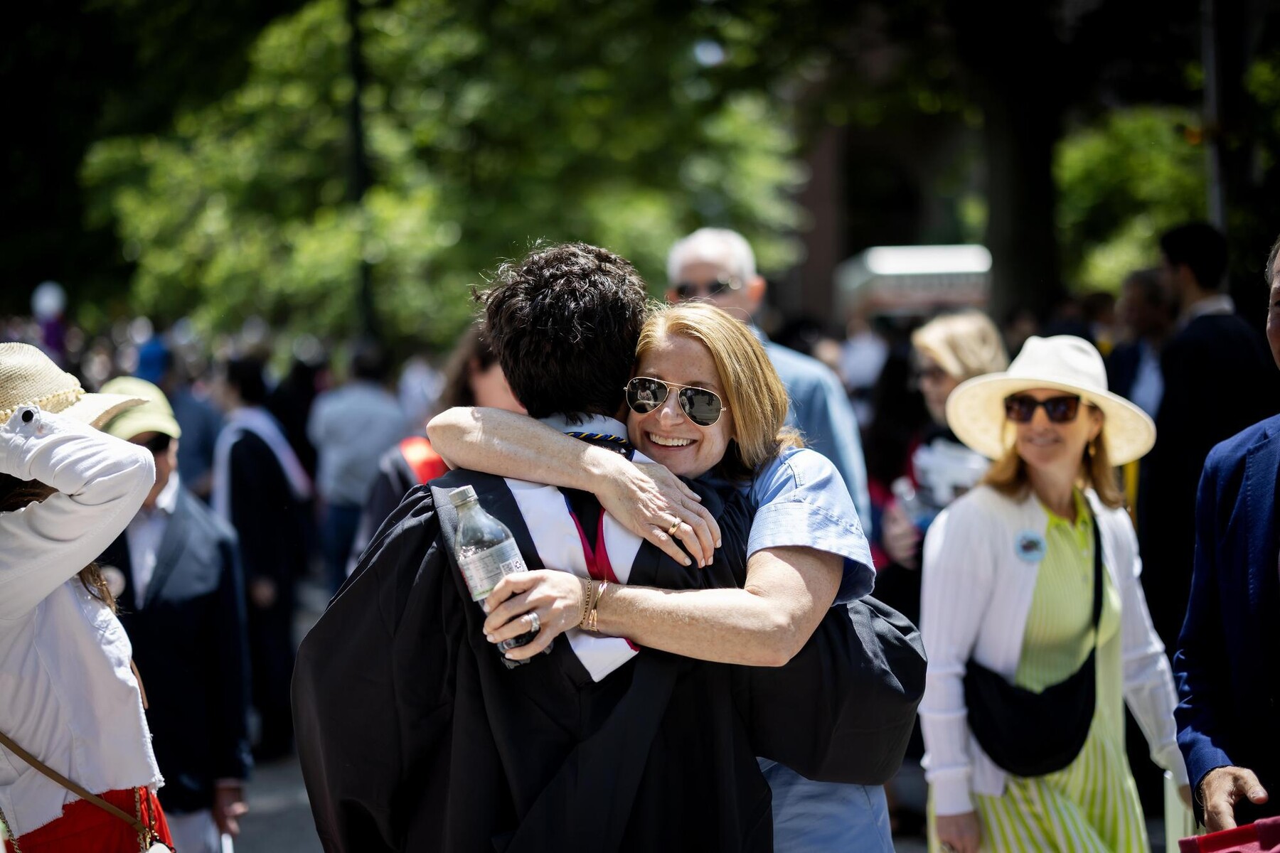 A graduate hugs someone after the Commencement ceremony.
