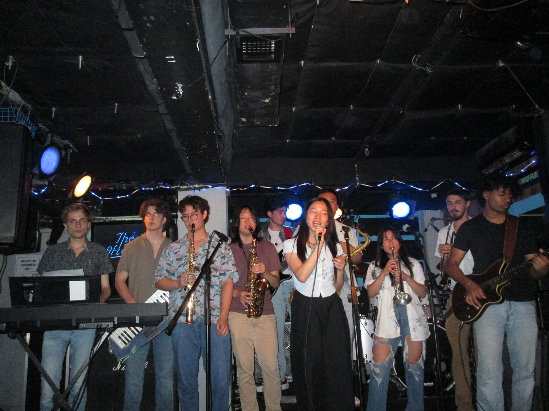 band with instruments on stage and person singing
