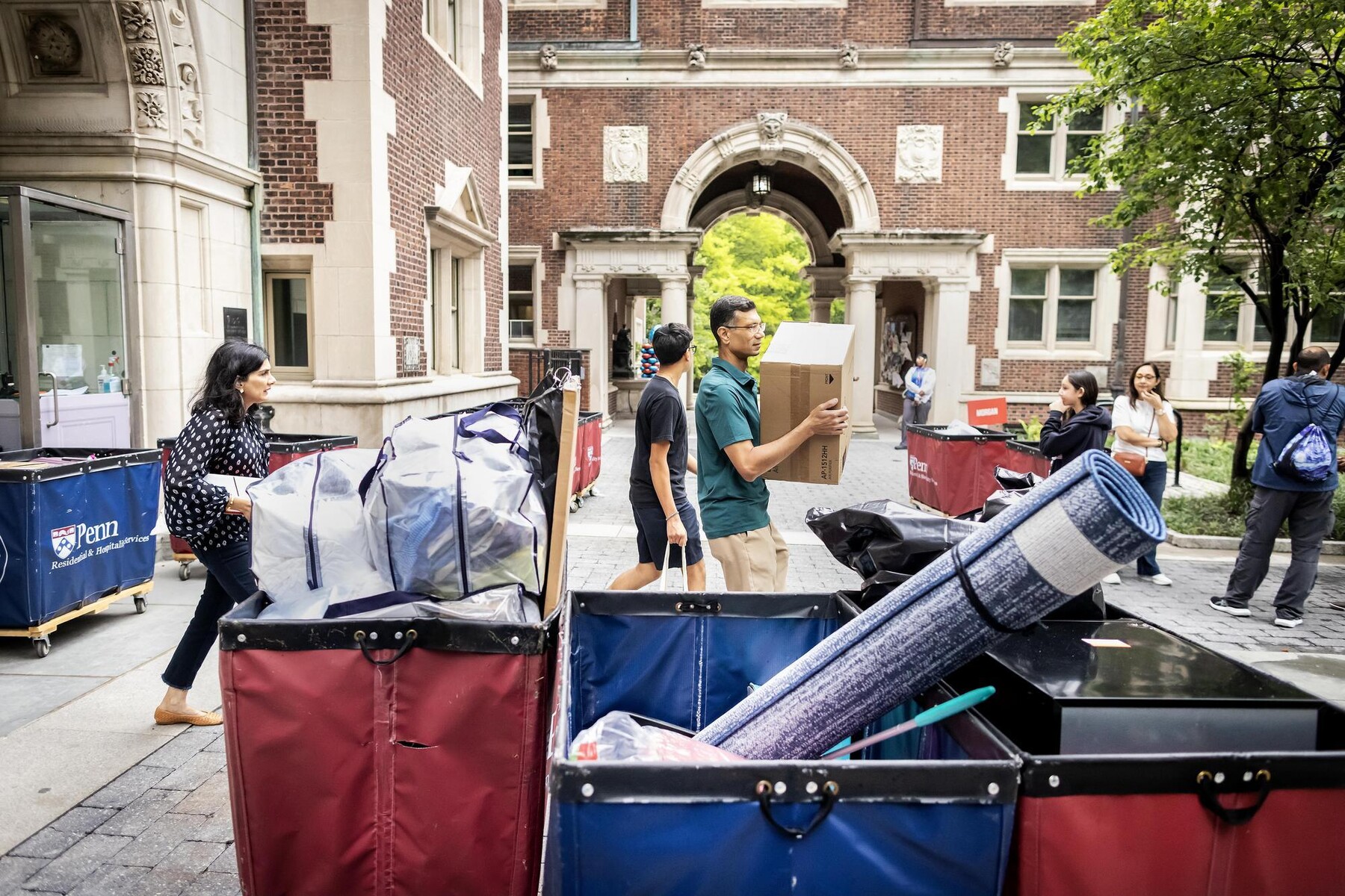 Students and families unloading move-in carts at Penn’s Quadrangle.
