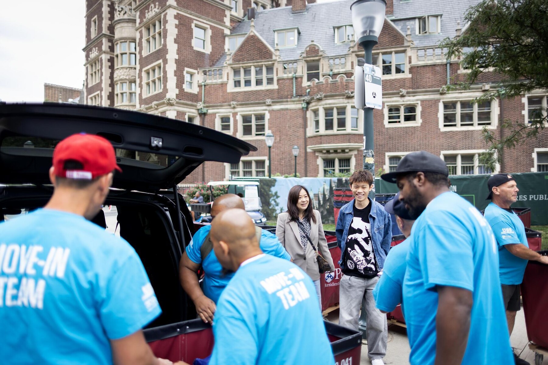 Move-In Team volunteers unload a car in front of the Quadrangle.