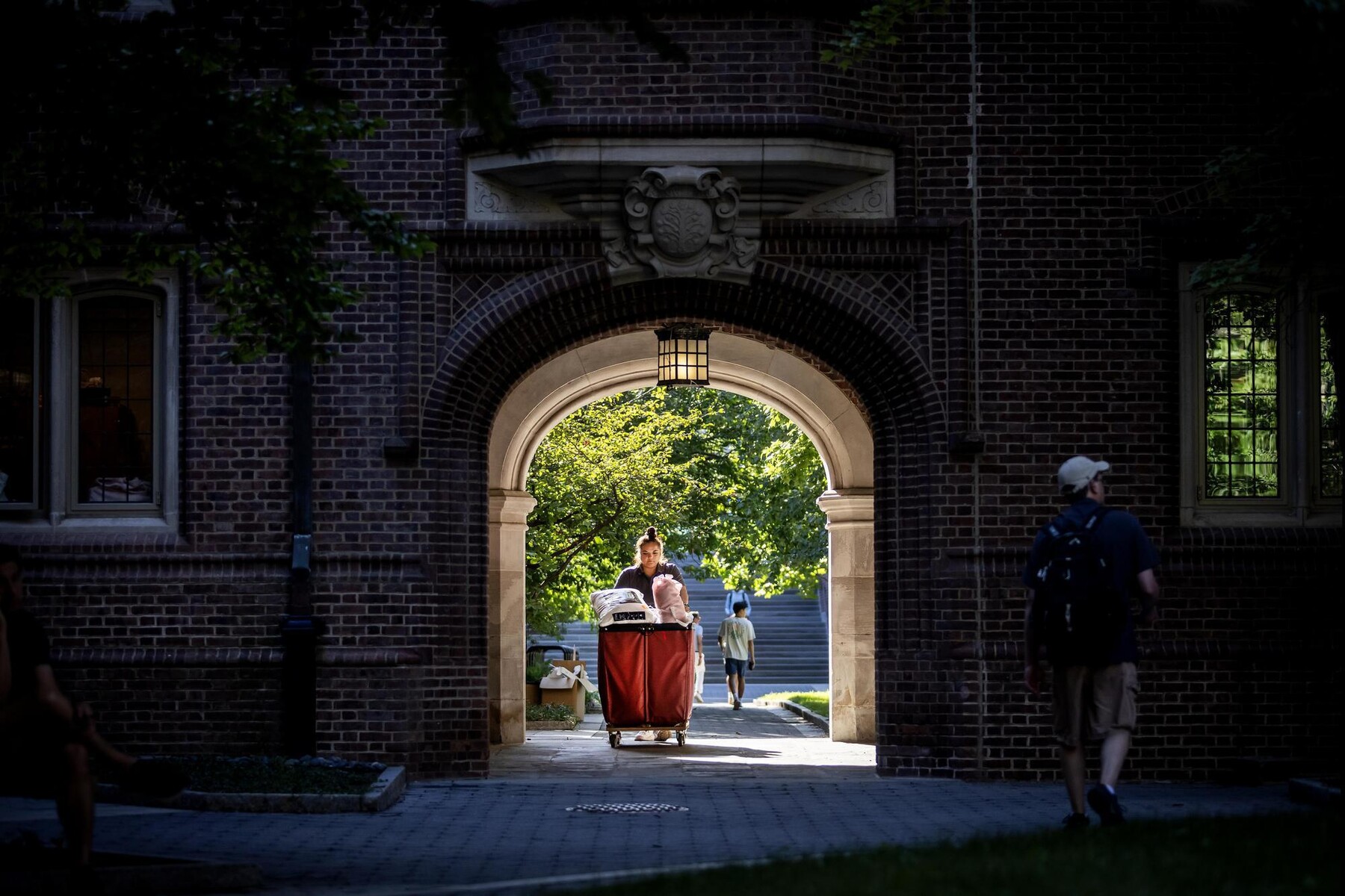 A student pushing a move-in cart outside a College House.