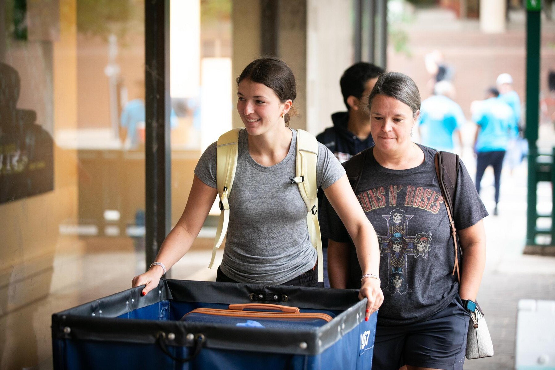 A student and their family member pushing a move-in cart on Move-In day at Penn.