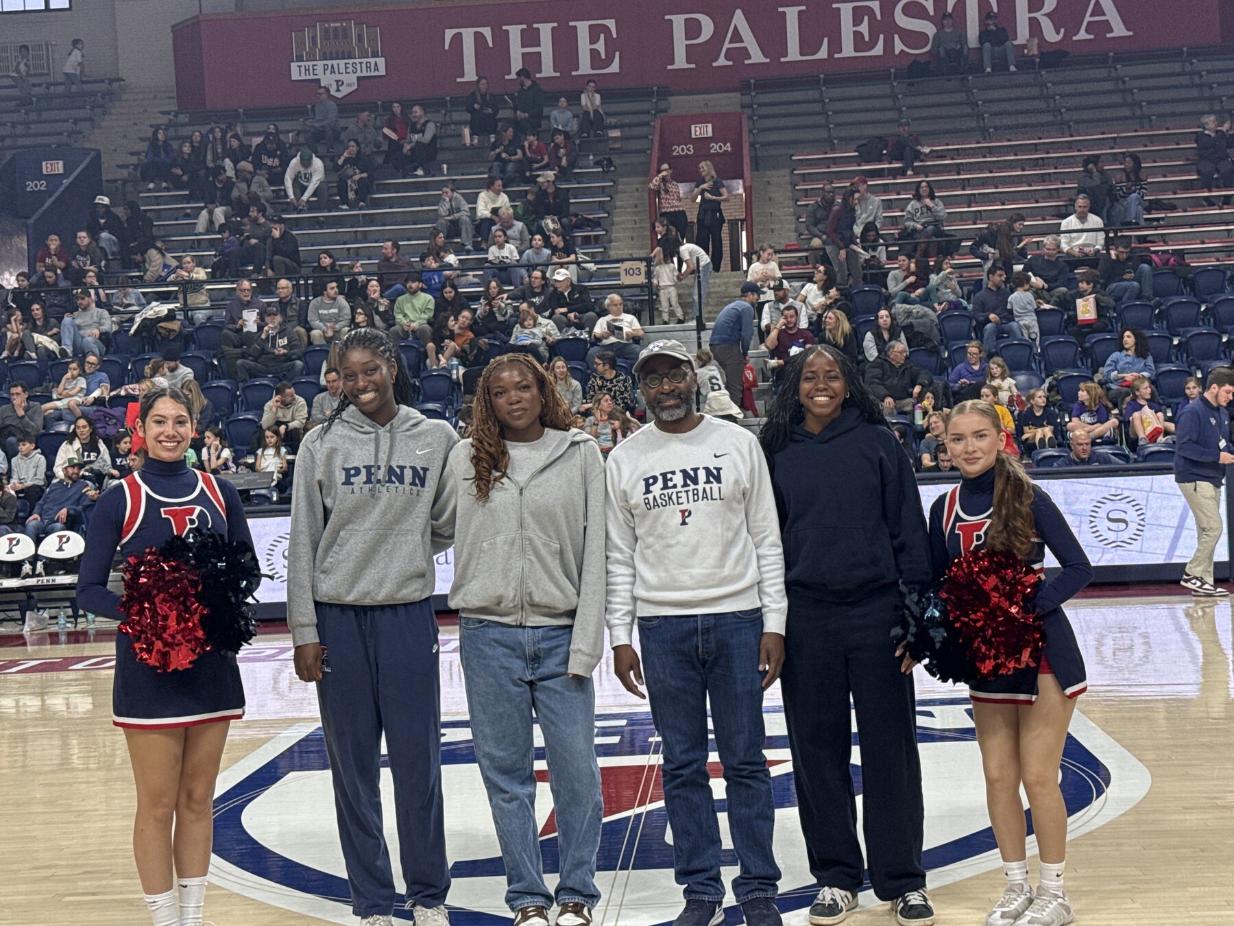 John L. Jackson Jr. and three players and two cheerleaders at a Penn basketball game.
