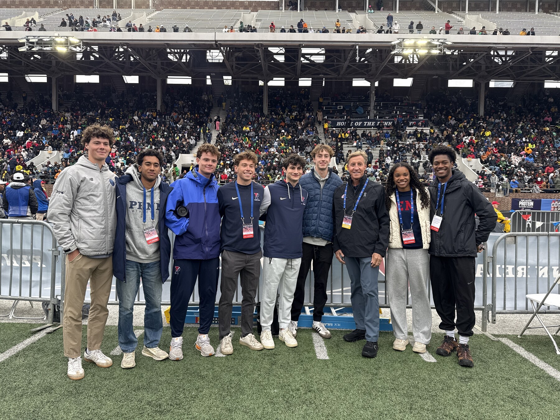 Penn President J. Larry Jameson and student athletes on Franklin Field.