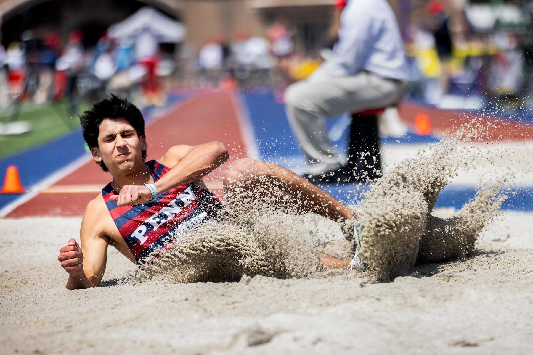 A long jumper in the sand post-jump.