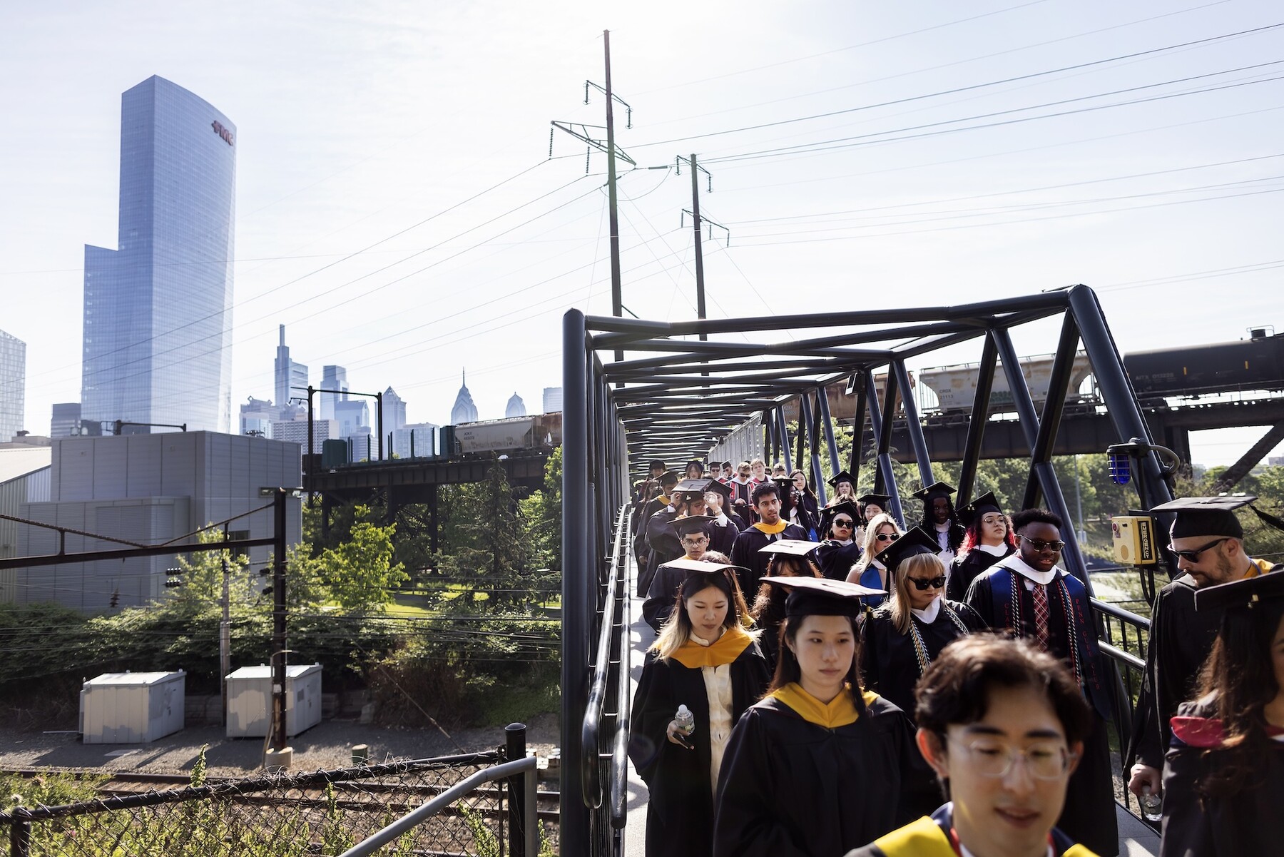 Students walking across a footbridge on the way to Penn’s commencement.