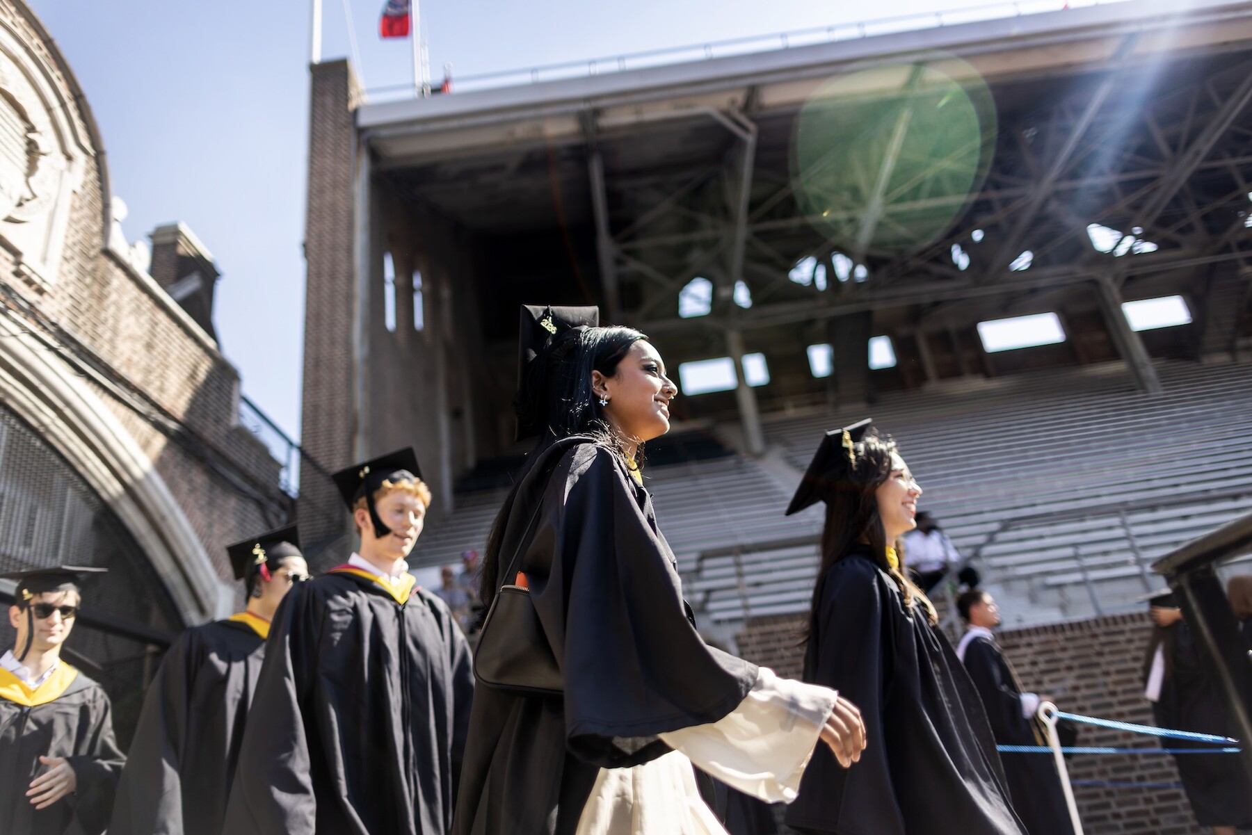 Students in regalia walking into Franklin Field.