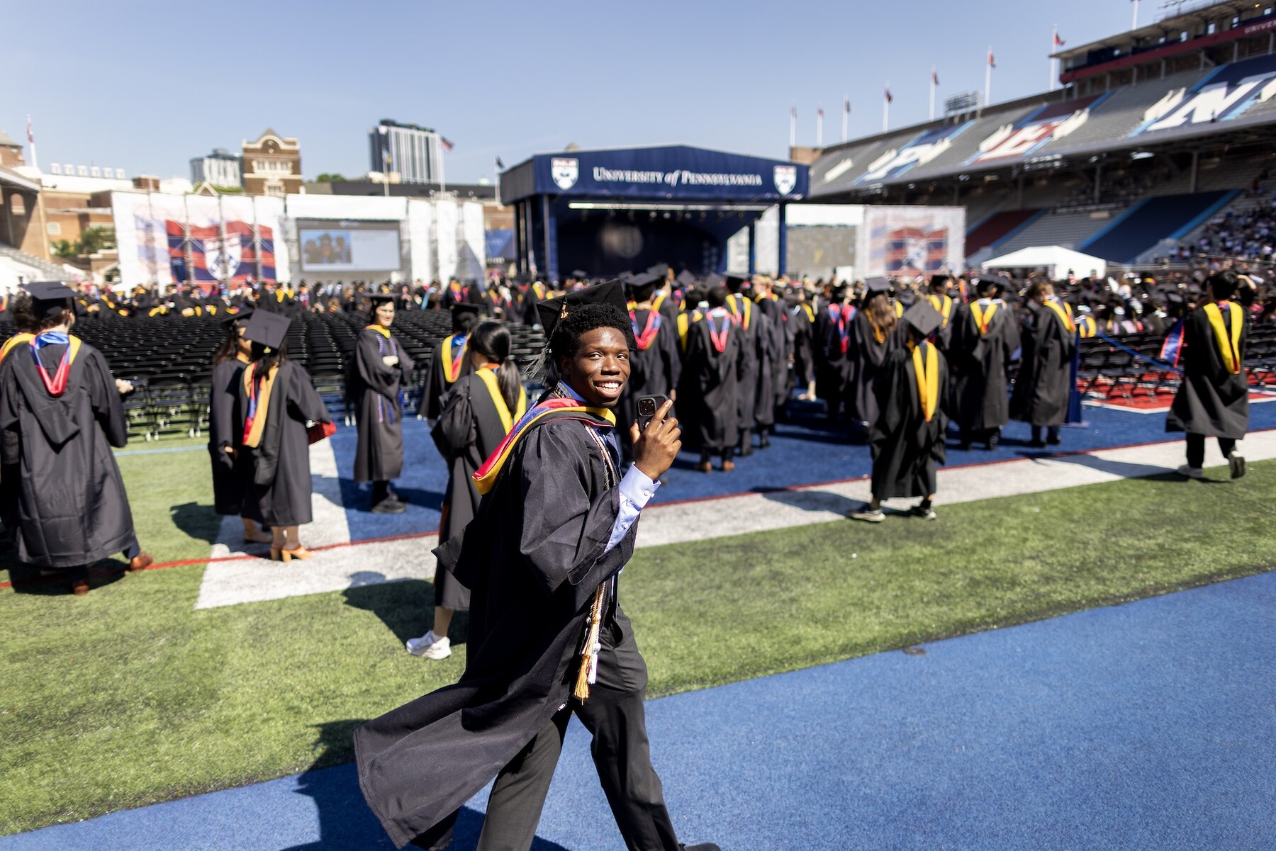 A student smiling walking onto franklin field.