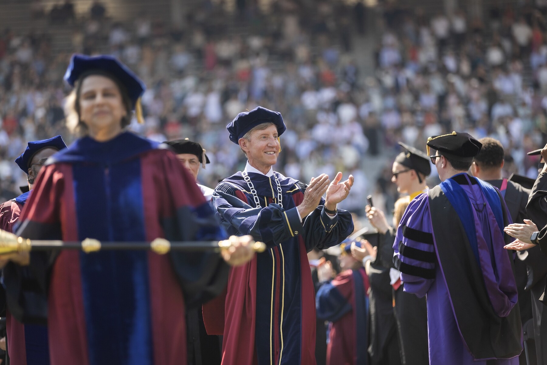 Medha Narvekar holding a mace and Penn President J. Larry Jameson walking behind her.