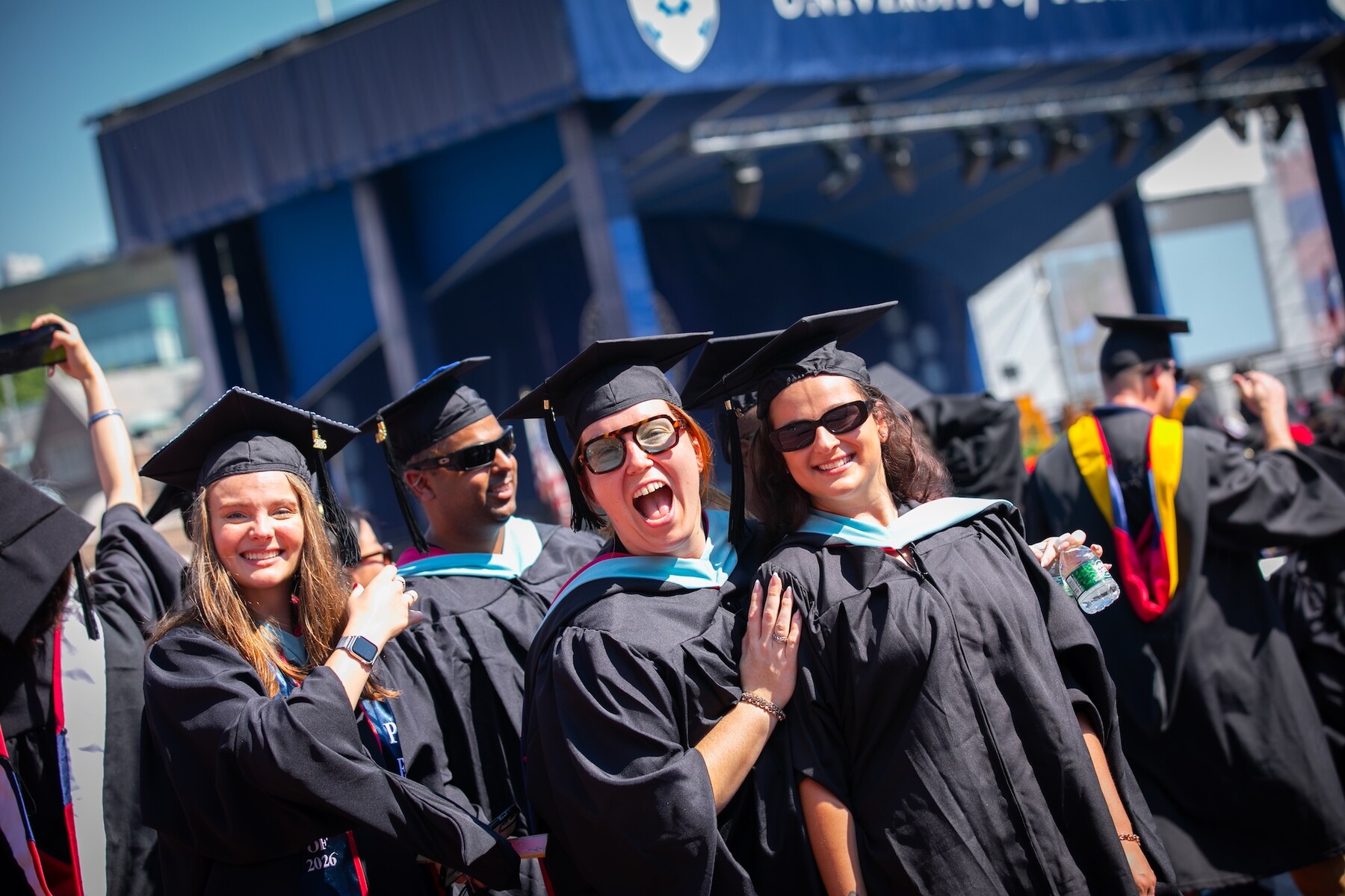 Students smiling on Franklin Field during Commencement