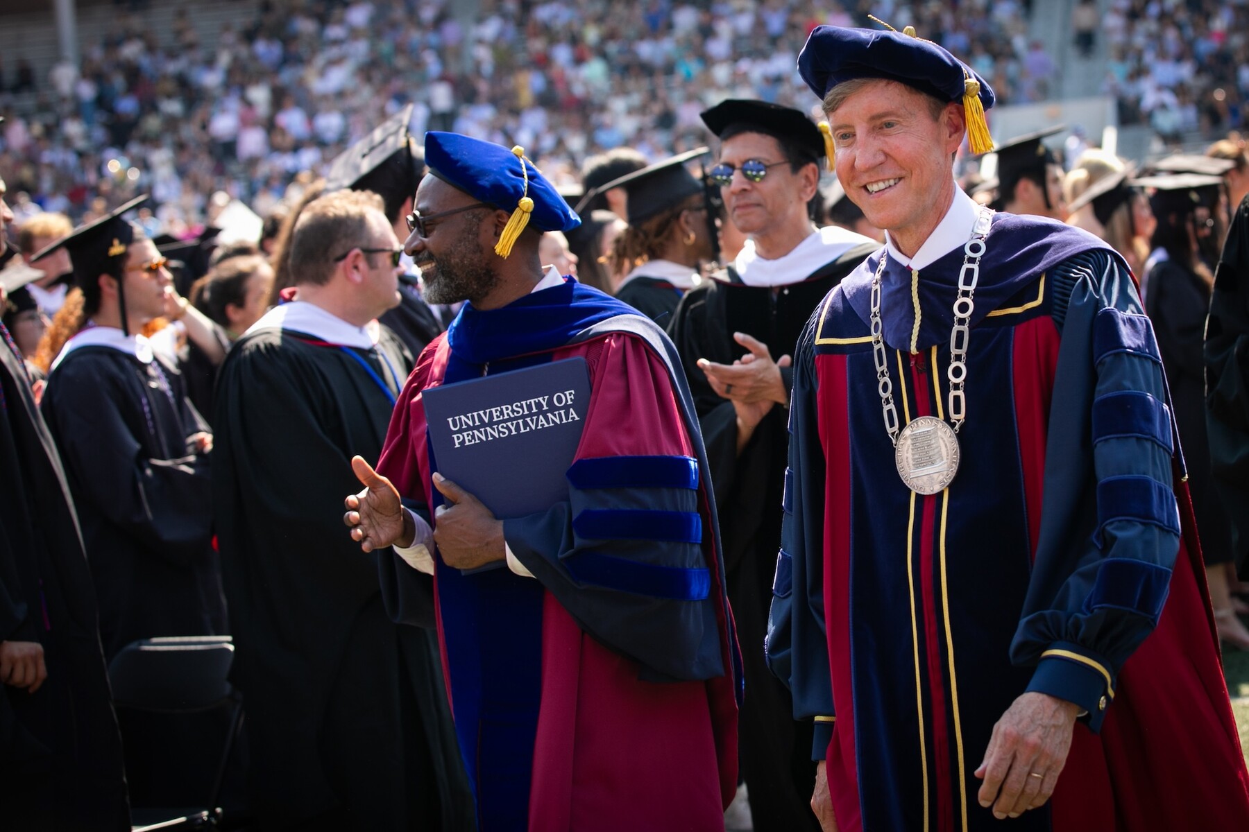 John L. Jackson Jr. and J. Larry Jameson in regalia walking on Franklin Field.
