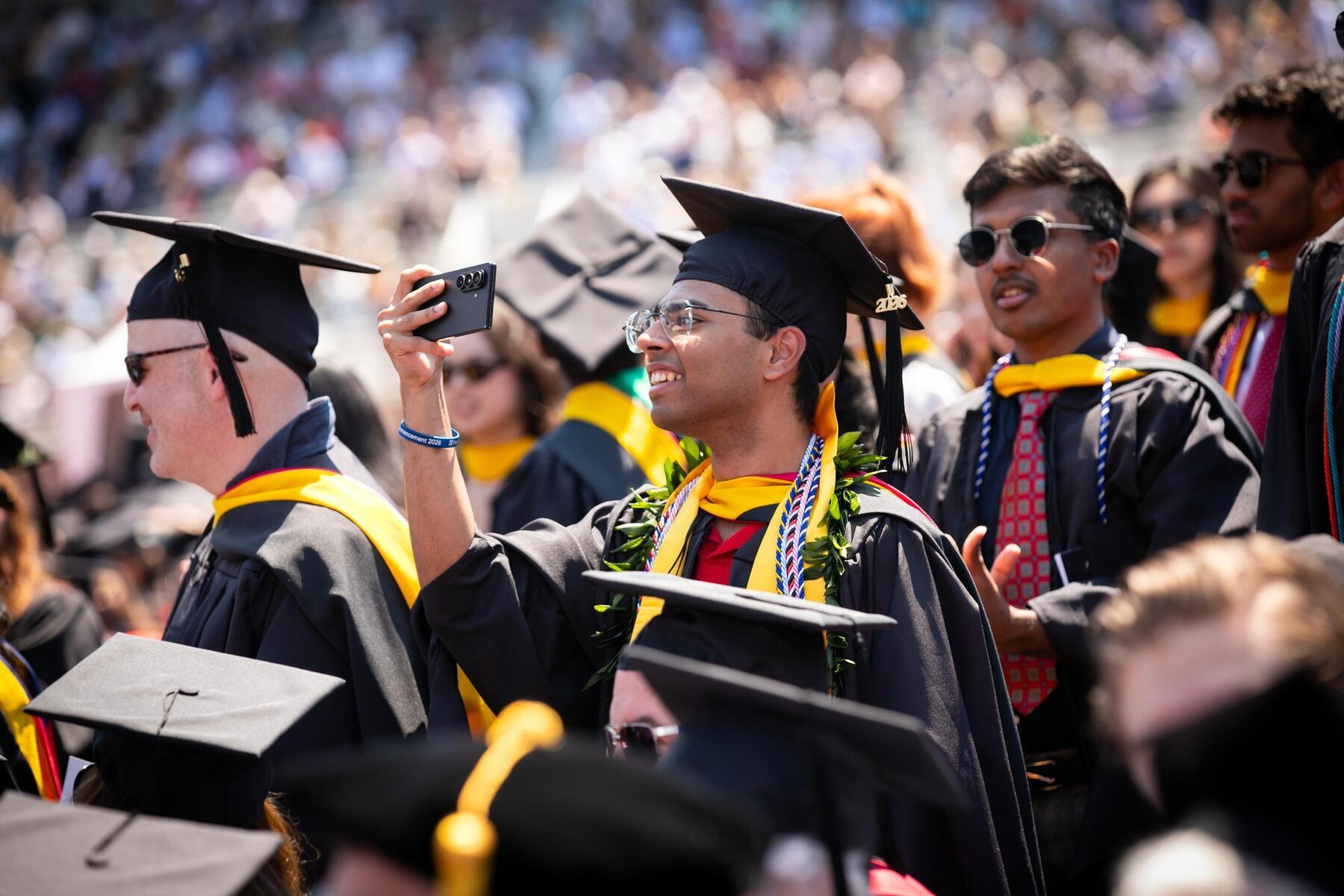 A graduate taking a selfie during commencement.