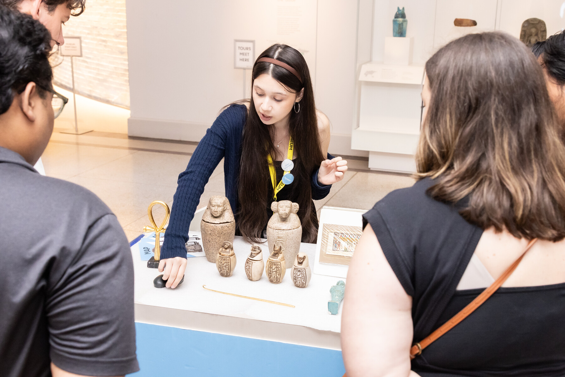 A docent showing artifacts on a table at the Penn museum.