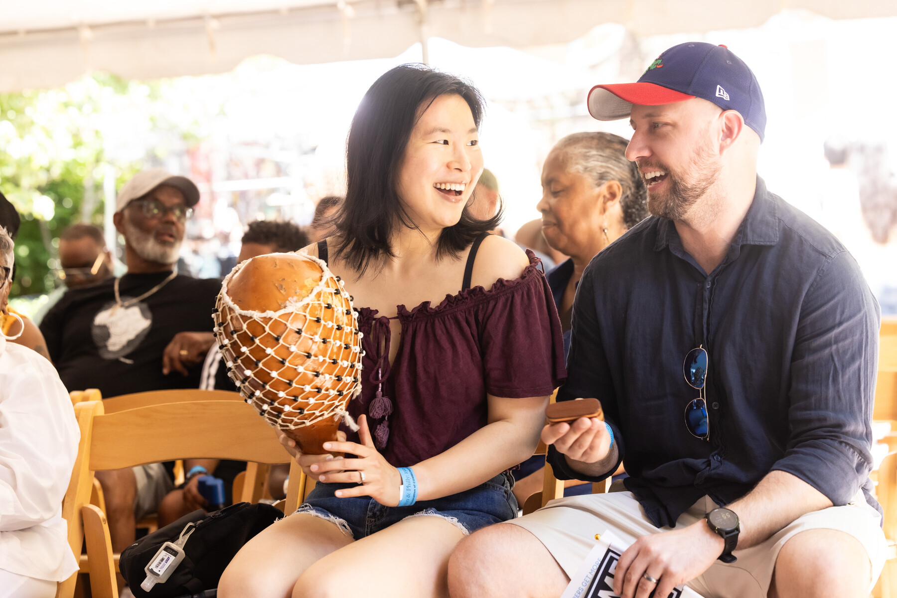 People playing musical instruments under a tent at the Penn Museum Juneteenth celebration.