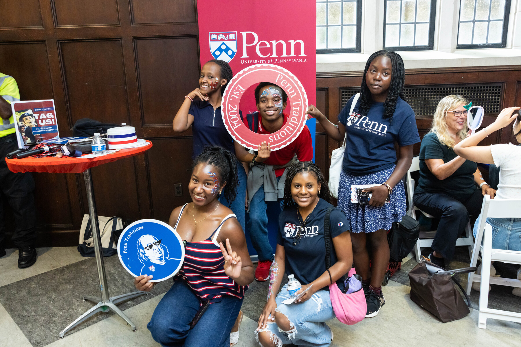 Penn students posing with Penn paraphernalia at Houston Hall.