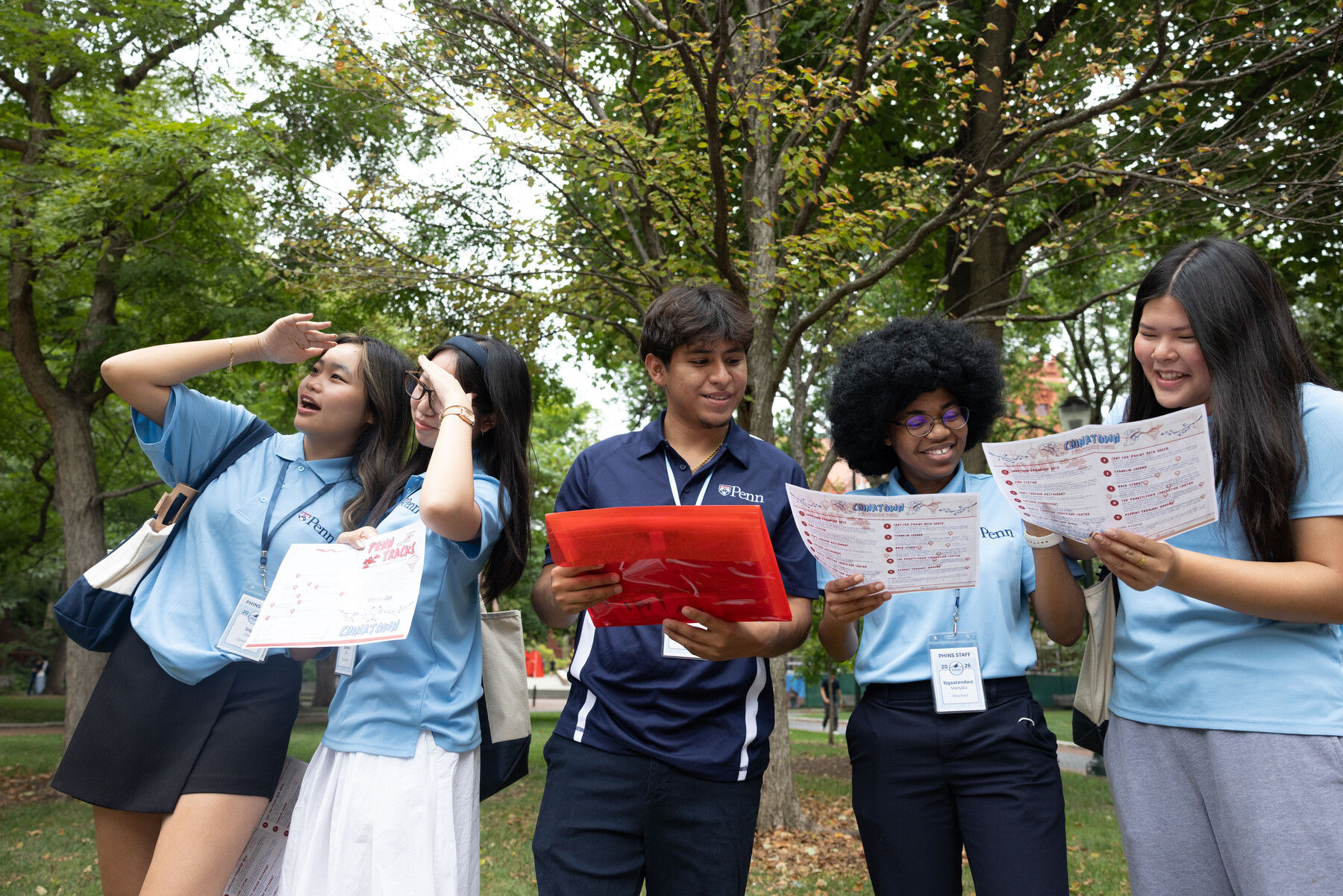 Five Penn students holding maps of the city.