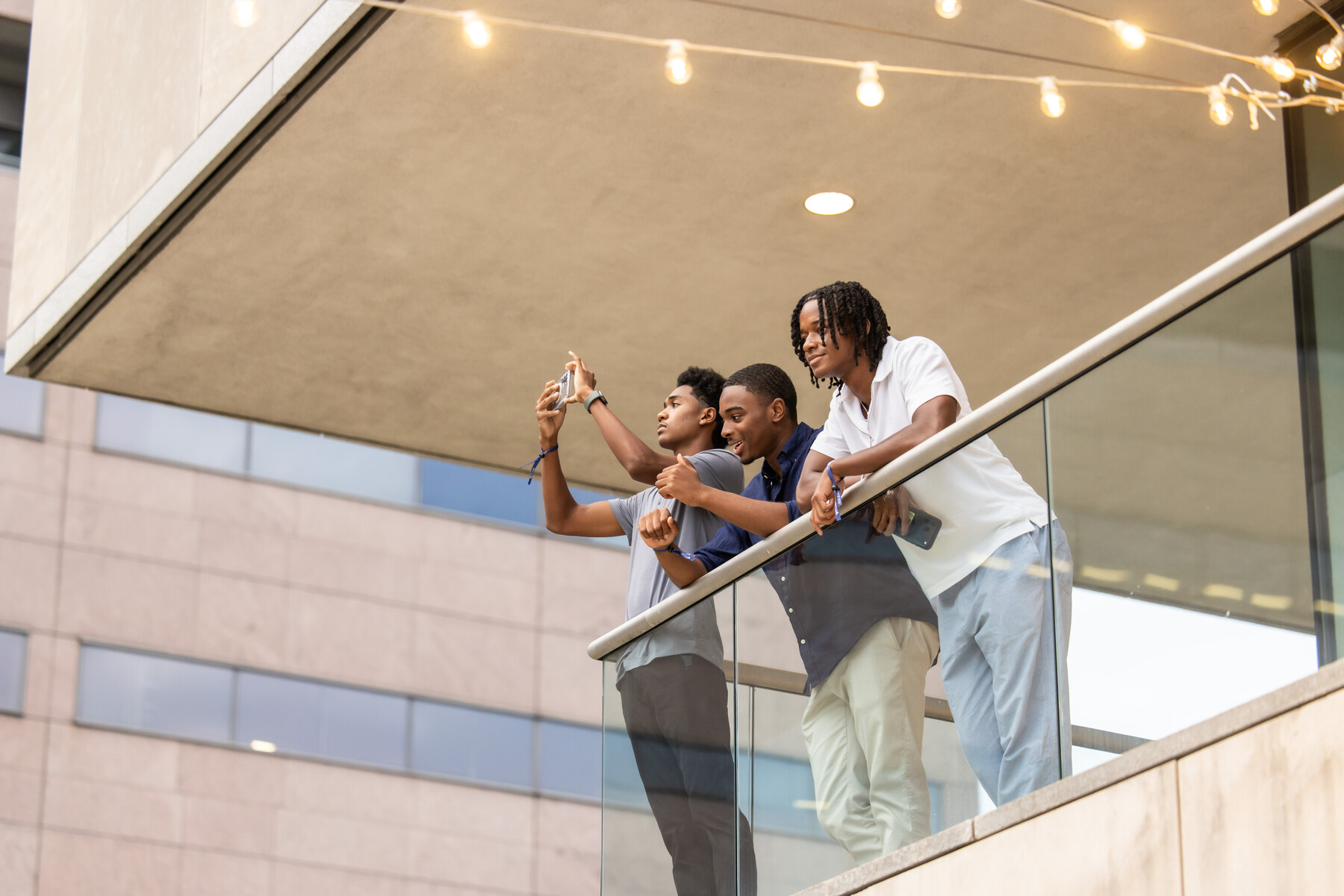 Three Penn students looking over a balcony at the Constitution Center.