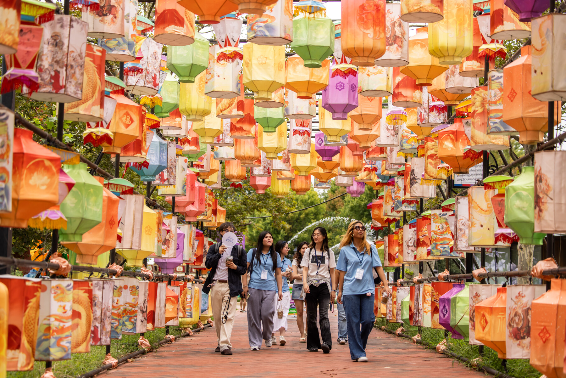 Penn students walking under a tunnel of paper lanterns in Chinatown.