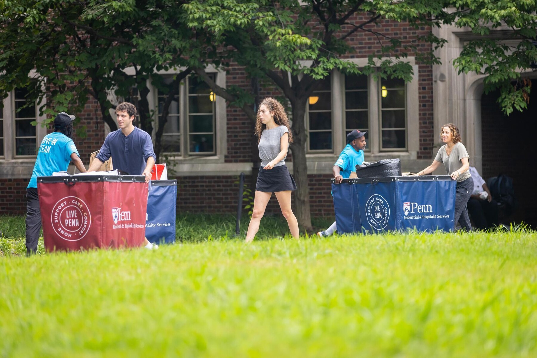 Students and Move-In staff pushing move-in carts outside the Quad.