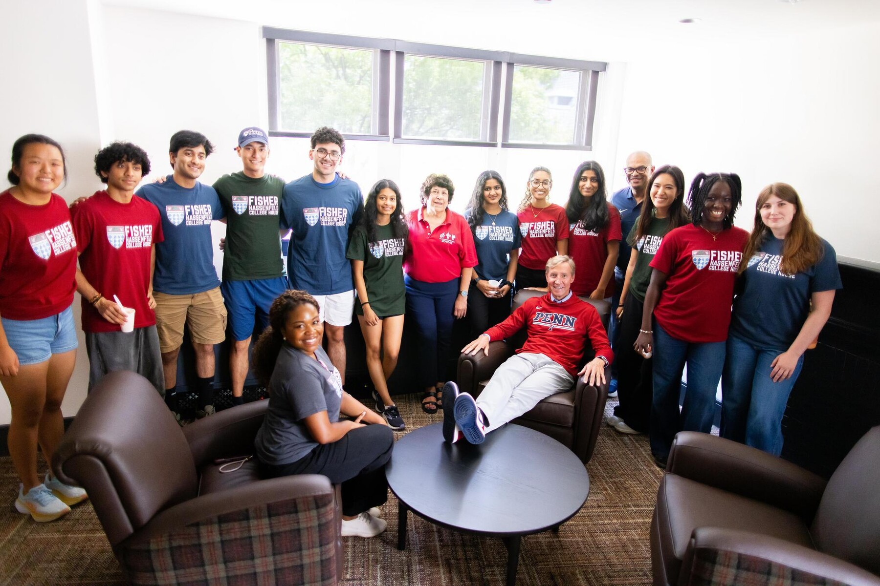 Penn President J. Larry Jameson seated in the Fisher Hassenfeld dorm surrounded by students.