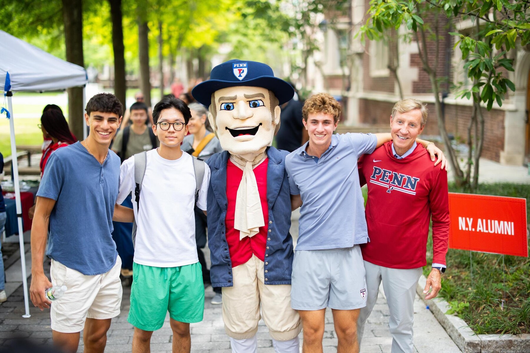 J. Larry Jameson, the Penn Quaker, and three students outside the Quad during Move-In.