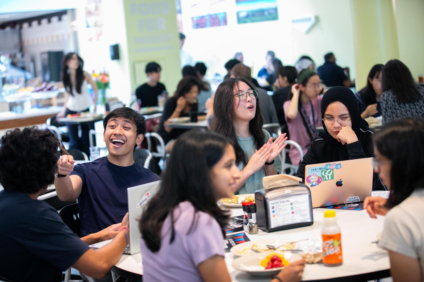 Students dining at a table in a dining hall during Move-In.