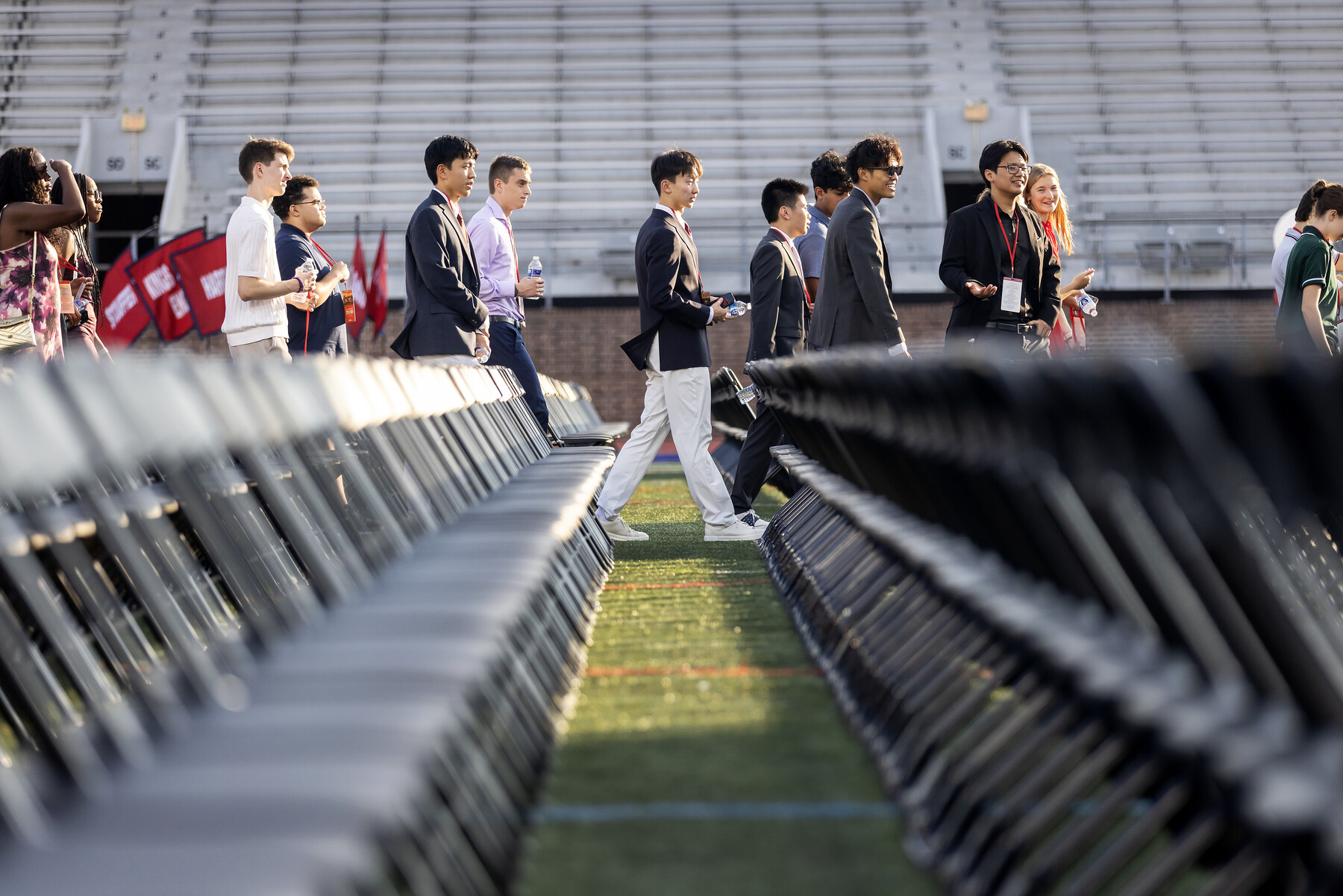 Class of 2030 students walking past chairs onto Franklin Field.