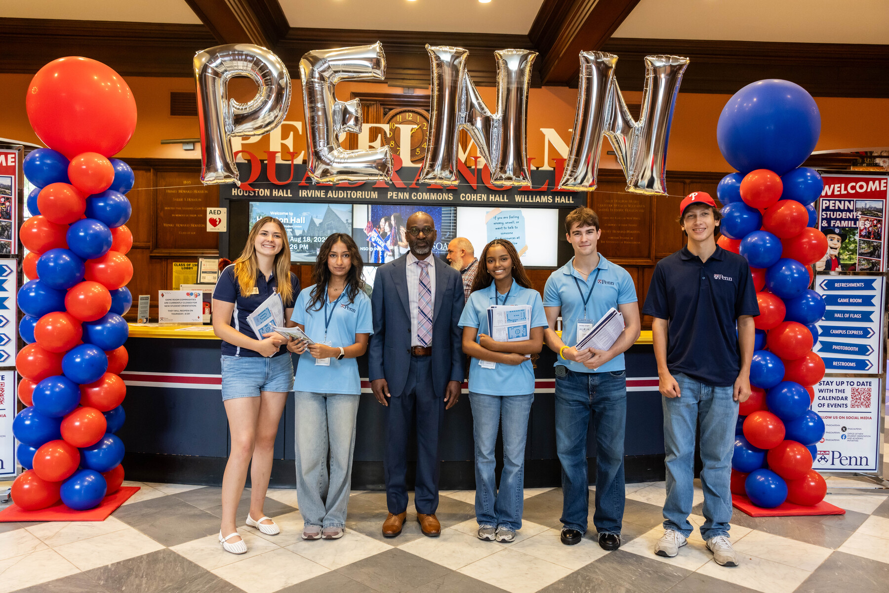 Penn Provost John L. Jackson, Jr. with five students under a Penn balloon arch.