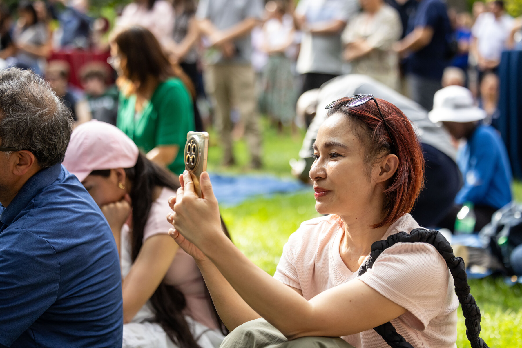A Penn parent taking a photo during the family picnic.