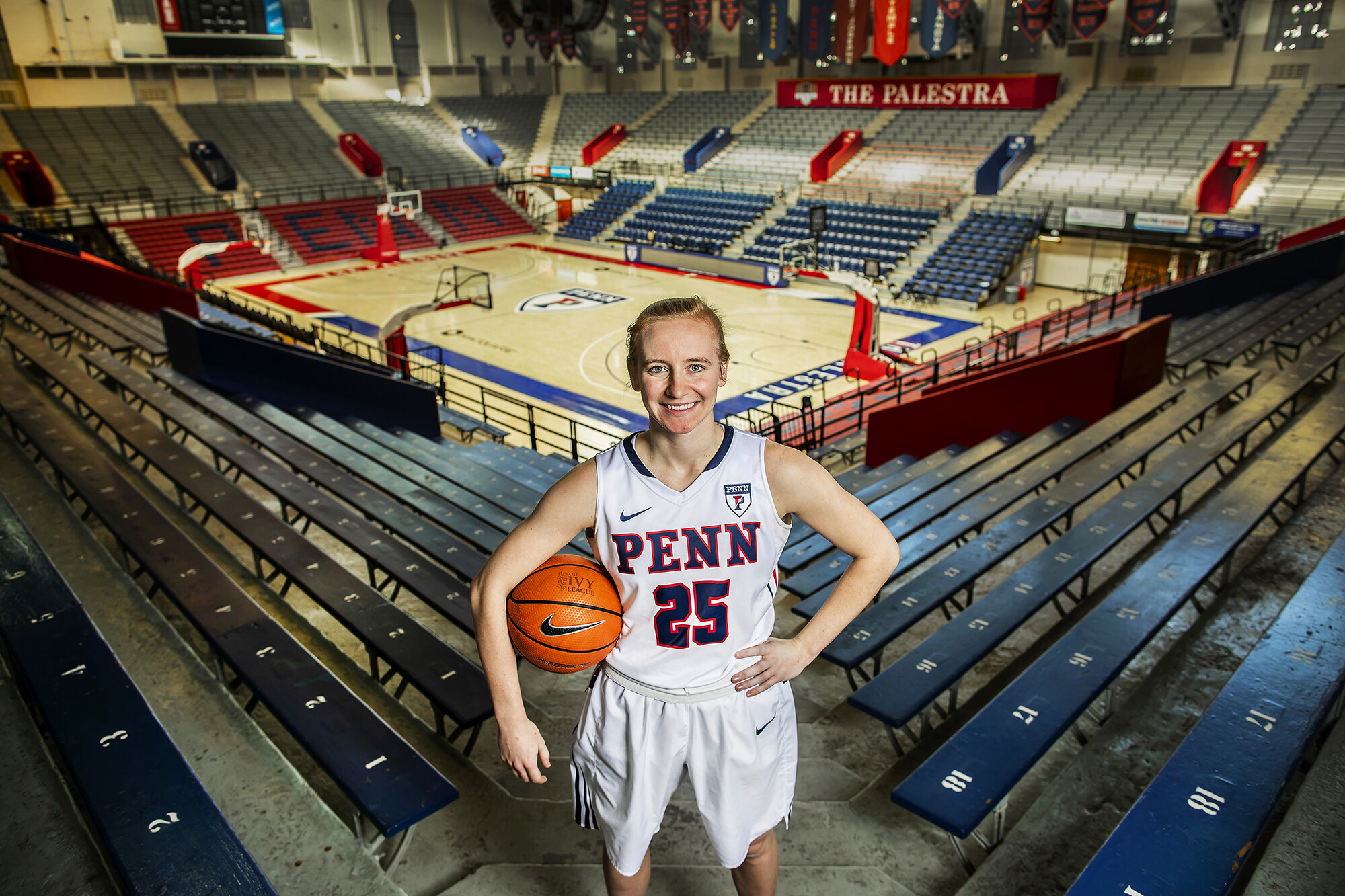 Ashley Russell of the women's basketball team poses with a ball in the Palestra bleachers.