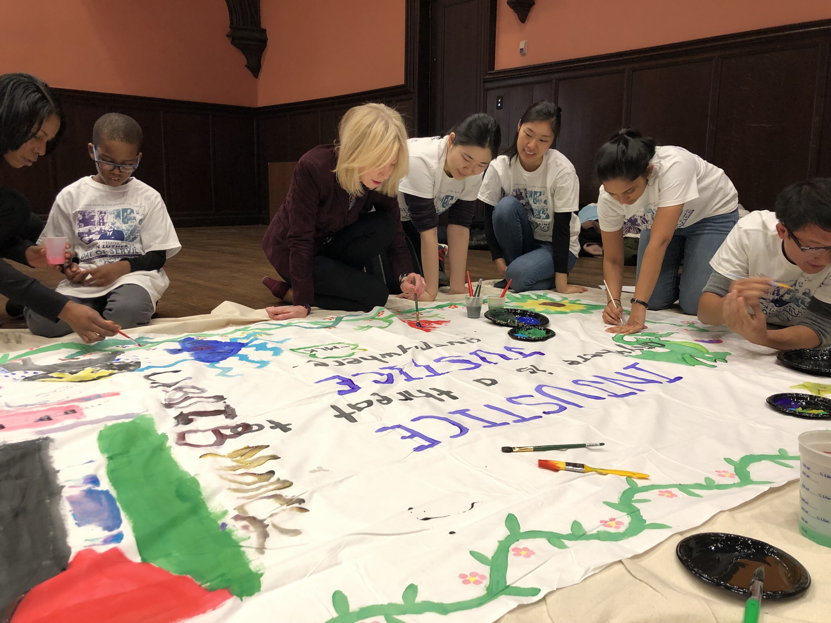 Amy Gutmann painting banners with children