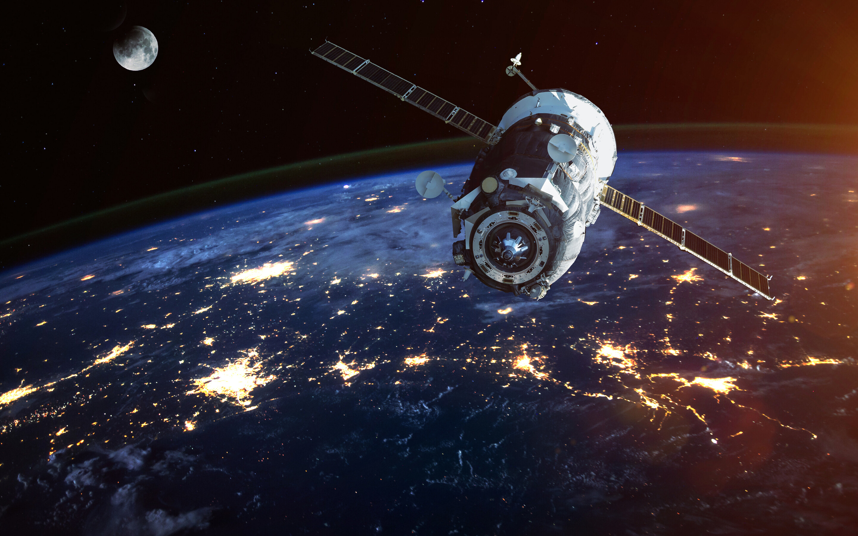 a satellite flying above earth with the moon in the distant background