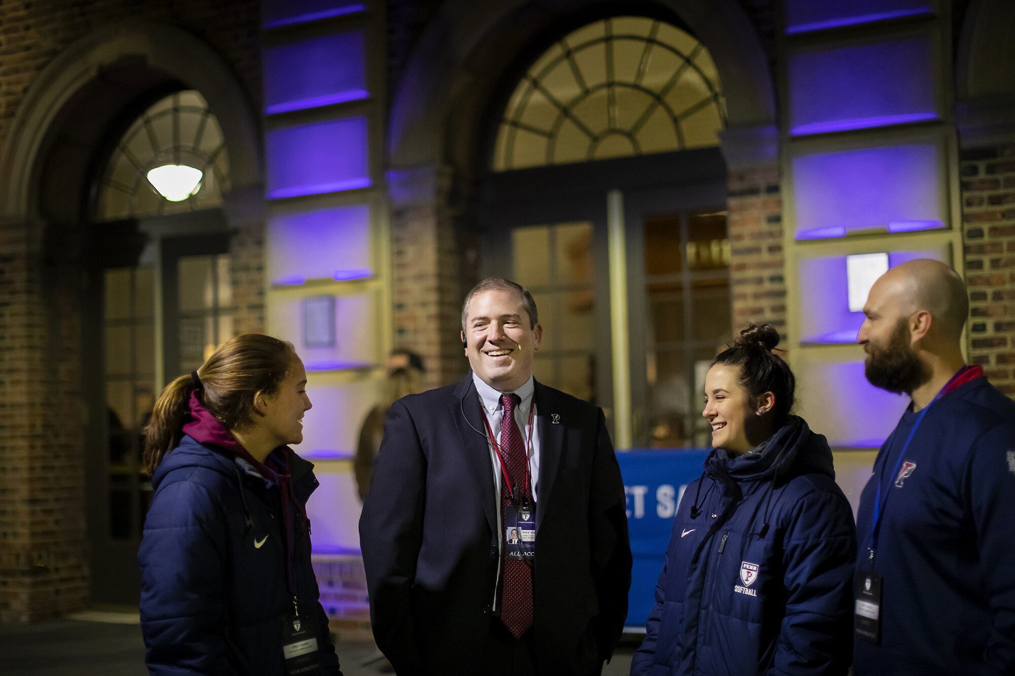 Director of Gameday Operations Mike Martin converse with three people outside the Palestra on game night.