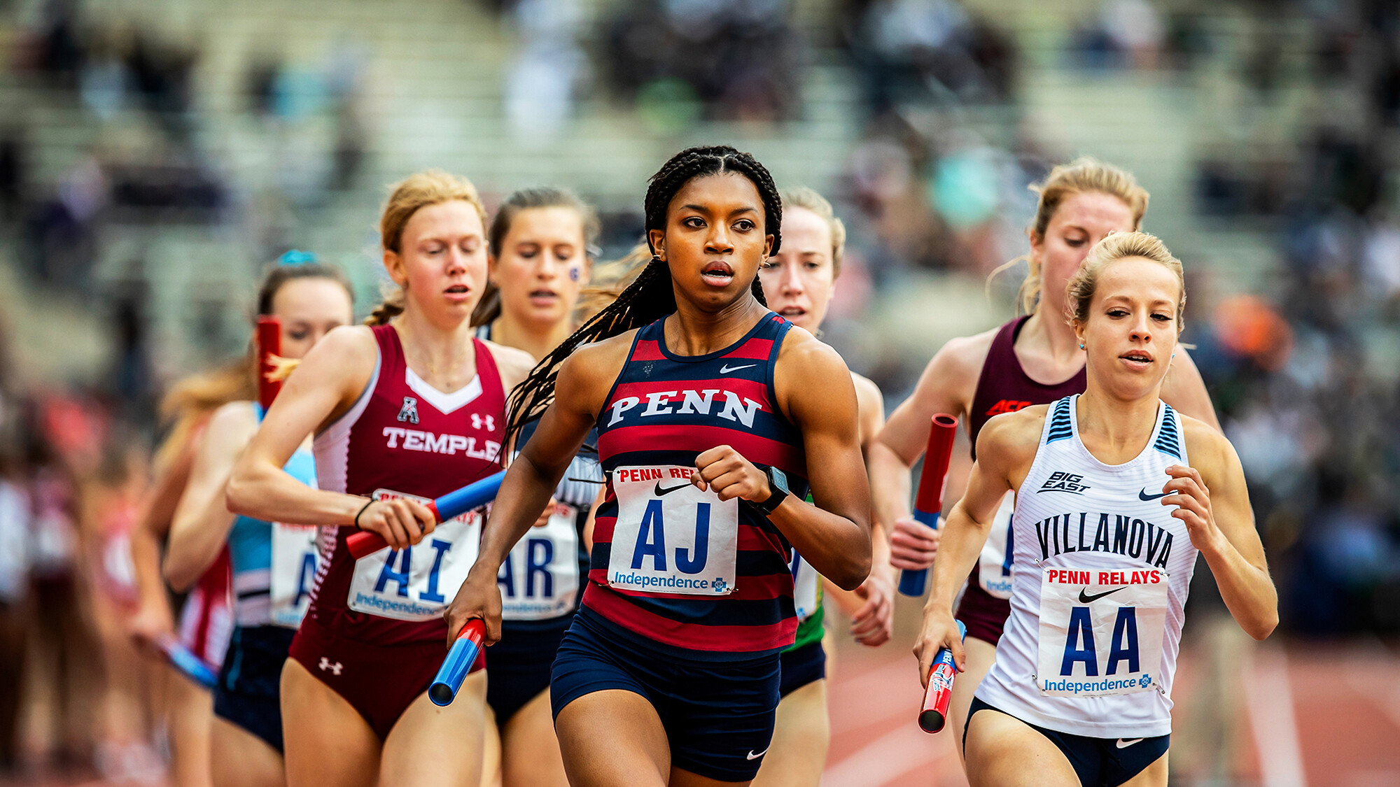 Nia Akins runs with the baton in her hand at the 2019 Penn Relays.