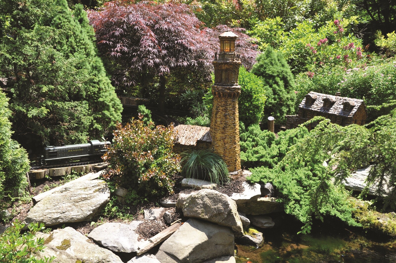 Lighthouse made from bar surrounded by greenery and rocks