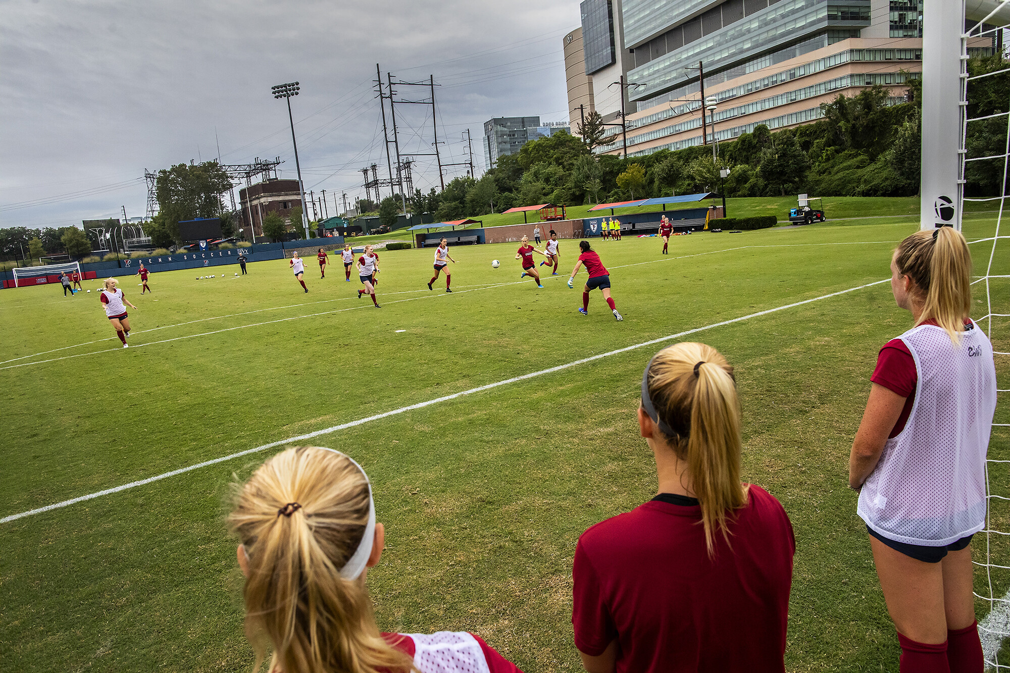 At practice, the red team battles the white team near the goal. The ball is in the middle of the pitch.