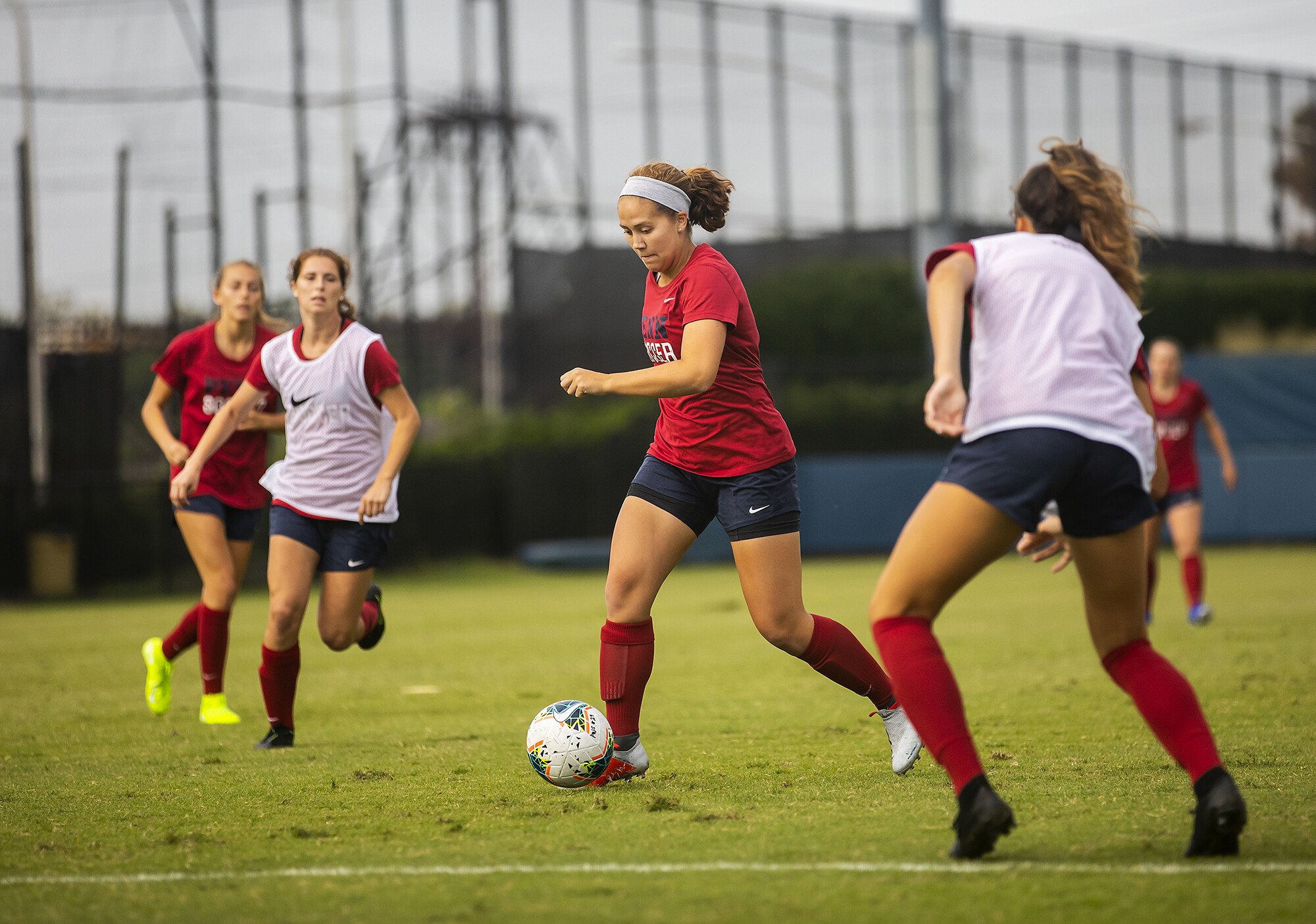 Senior Emily Sands dribbles the ball between two defenders at practice.