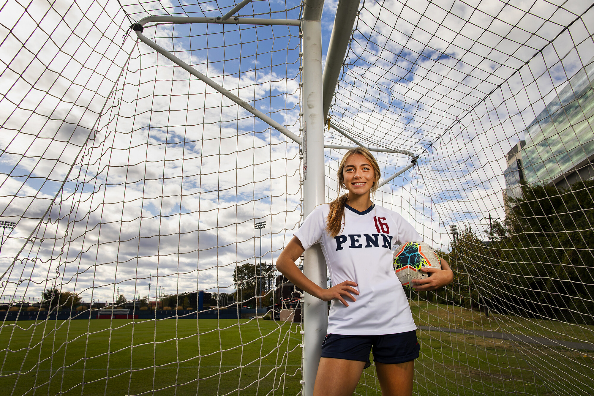 Breukelen Woodard of the women's soccer team poses with a ball inside a soccer goal at Rhodes Field.