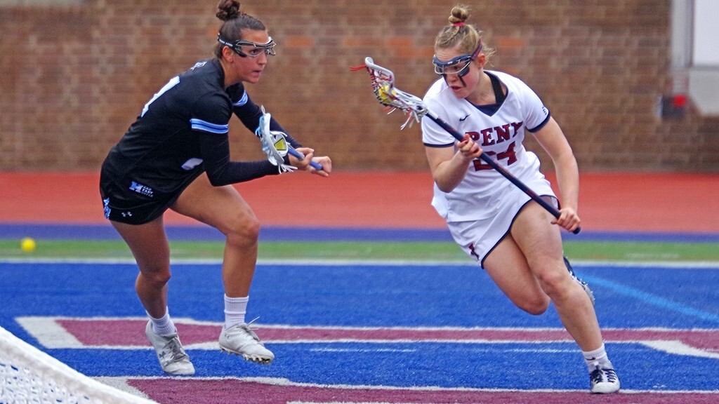 Rosenzweig runs past opposing player with the ball in their stick