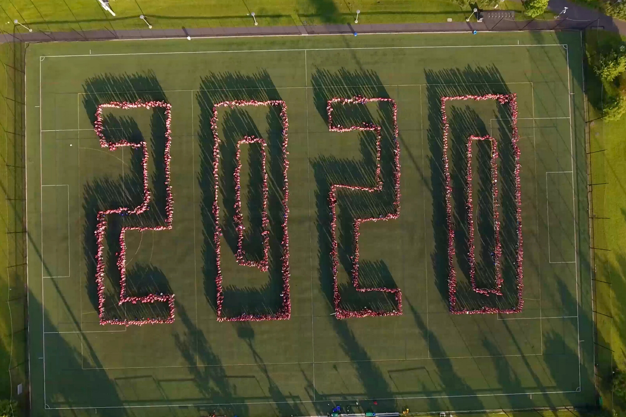 bird's eye view of bright green playing field in Penn Park with members of the Class of 2020 spelling out 2020.