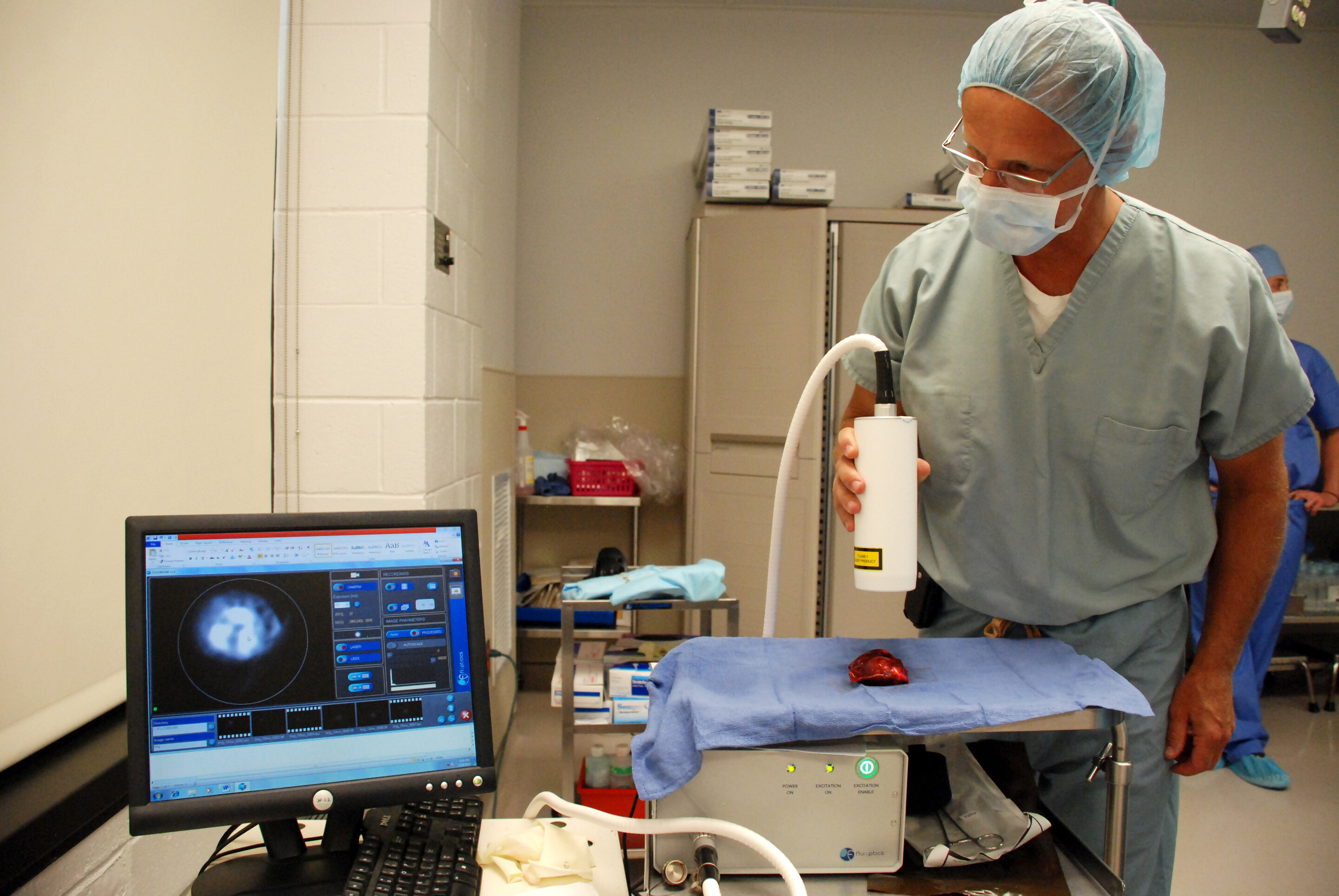 Surgeon uses an imaging machine to assess a tumor
