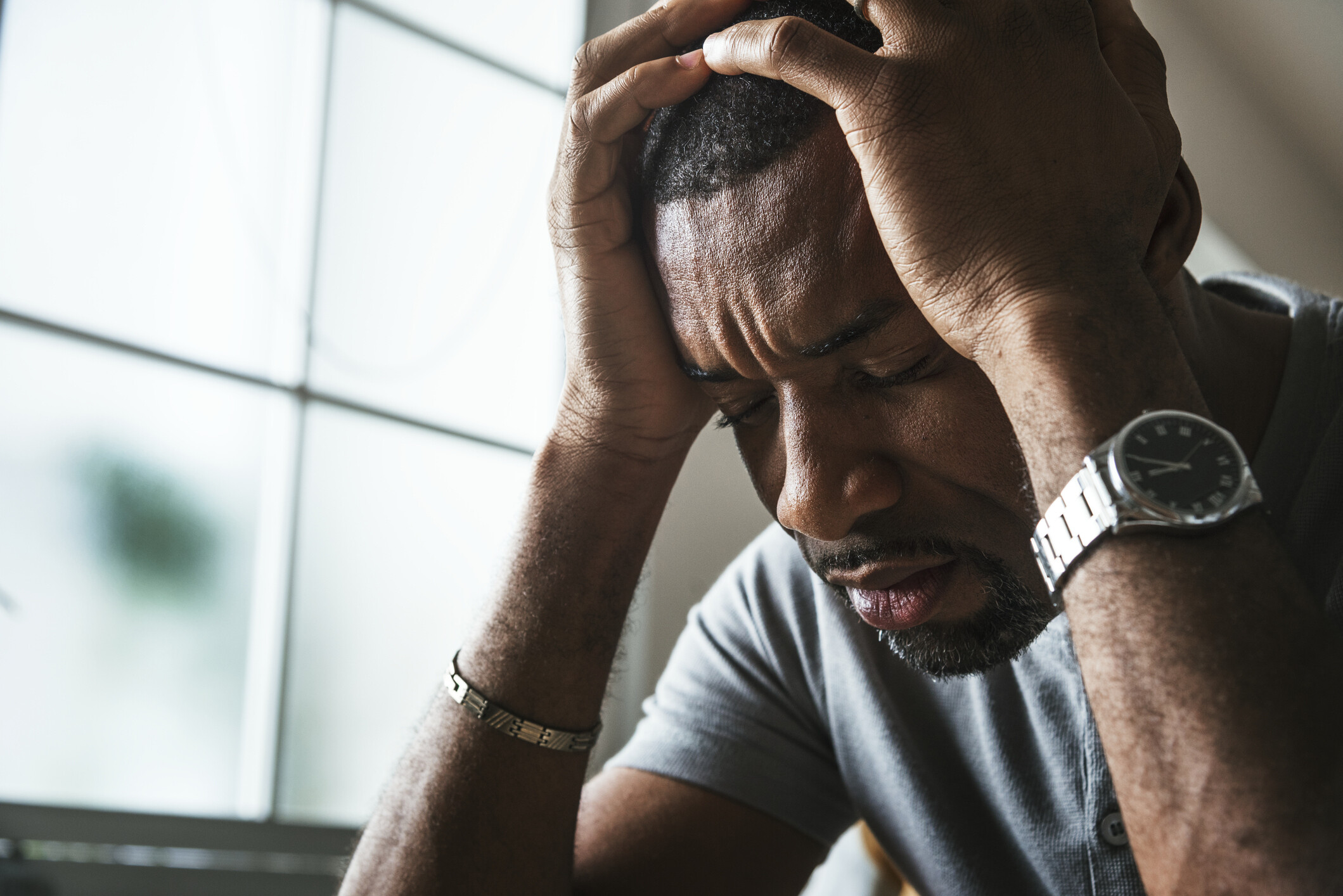 african american person holding their head