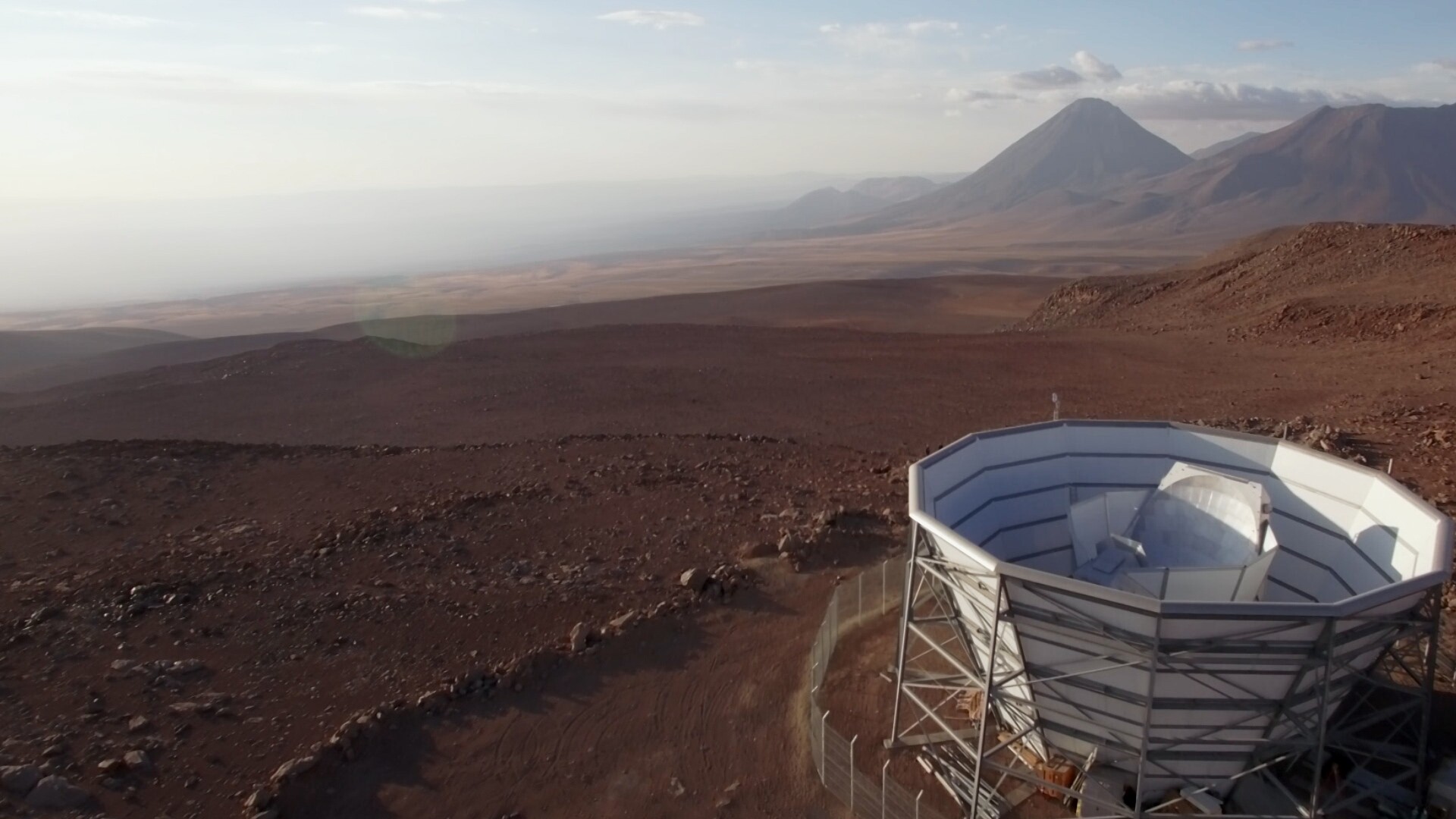 the Atacama Cosmology Telescope in the foreground and the desert and mountains of chile in the background