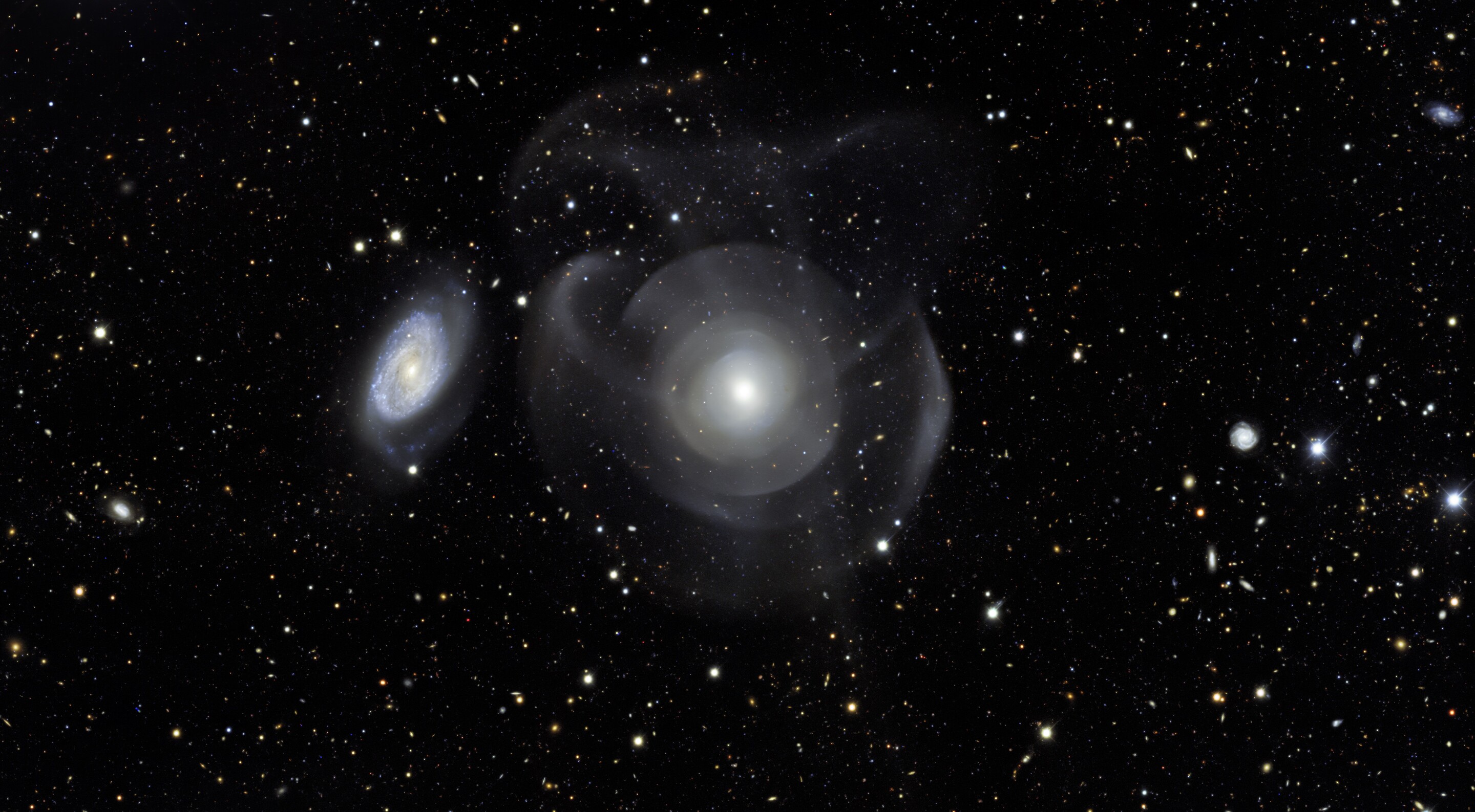 rendering of the elliptical galaxy NGC 474 and spiral galaxy 470 with star shells