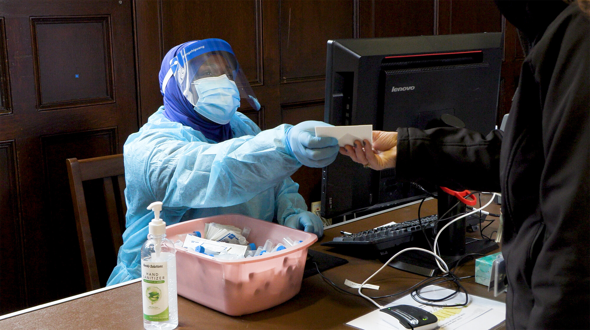 lab tech handing paper to job seeker